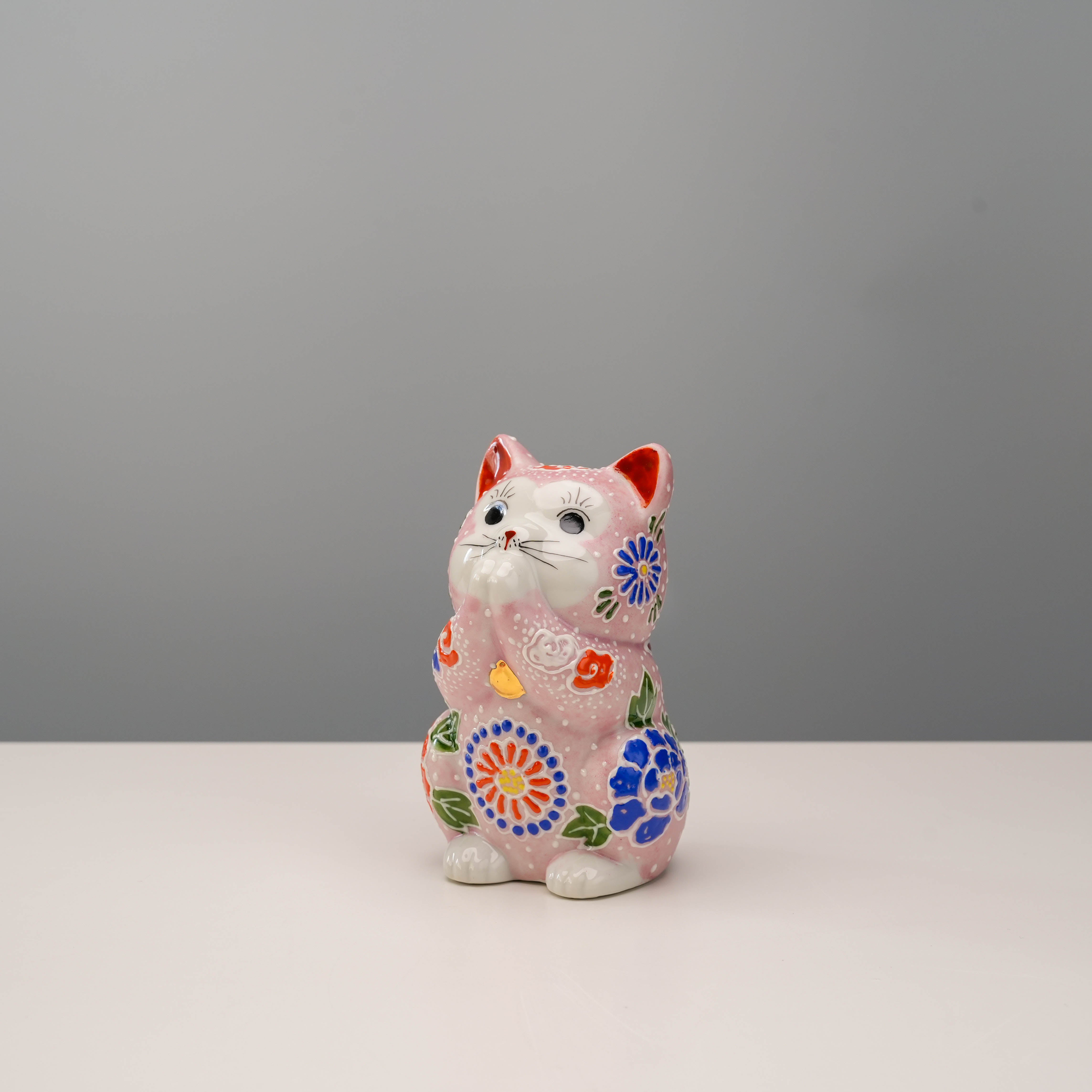 Kutani Ware Cat Ornament - Lucky Cat in pink floral design, hand-painted ceramic figurine in a praying pose for home decor.
