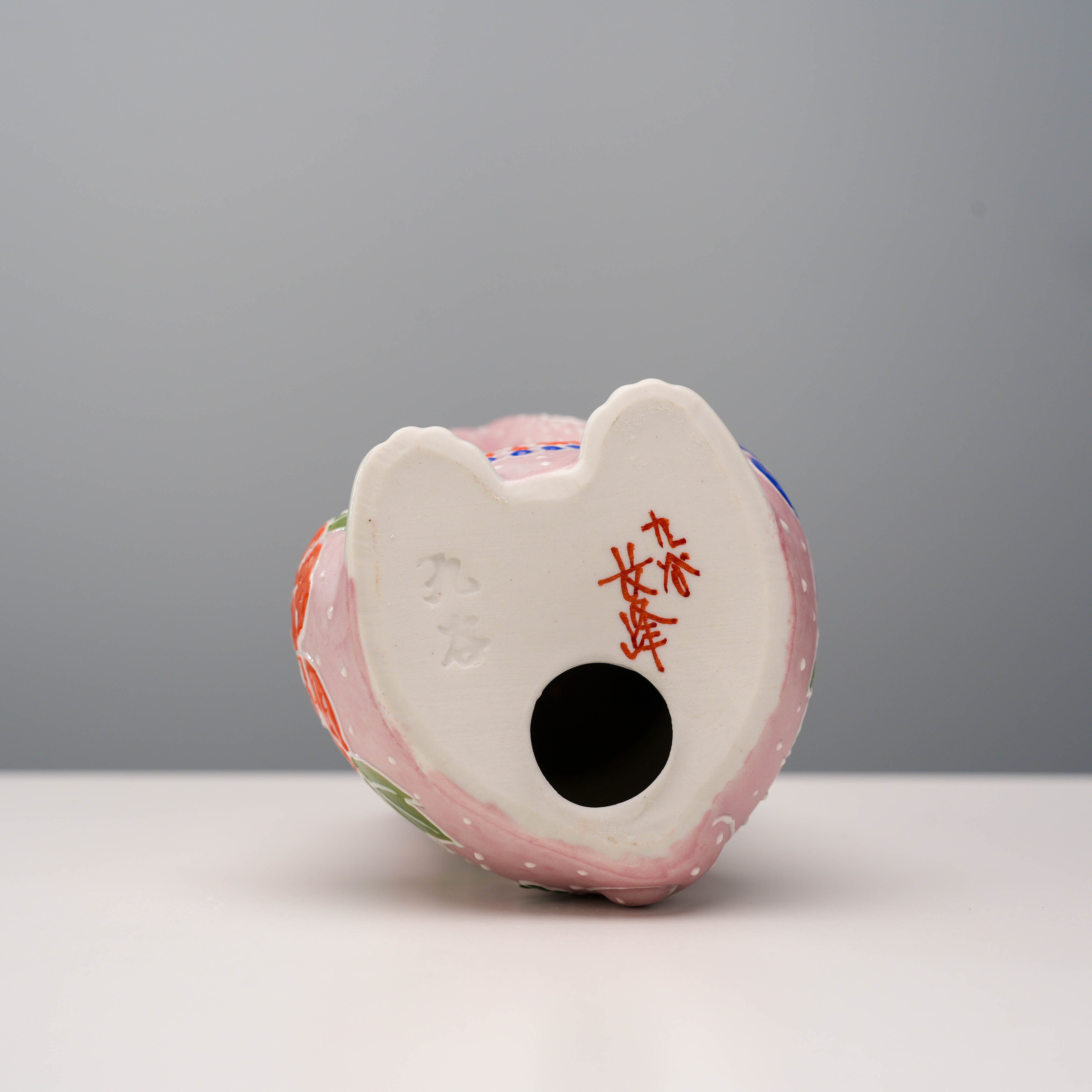 Bottom view of Kutani Ware Cat Ornament showing signature markings and hollow base, part of the Lucky Cat pink floral figurine collection.