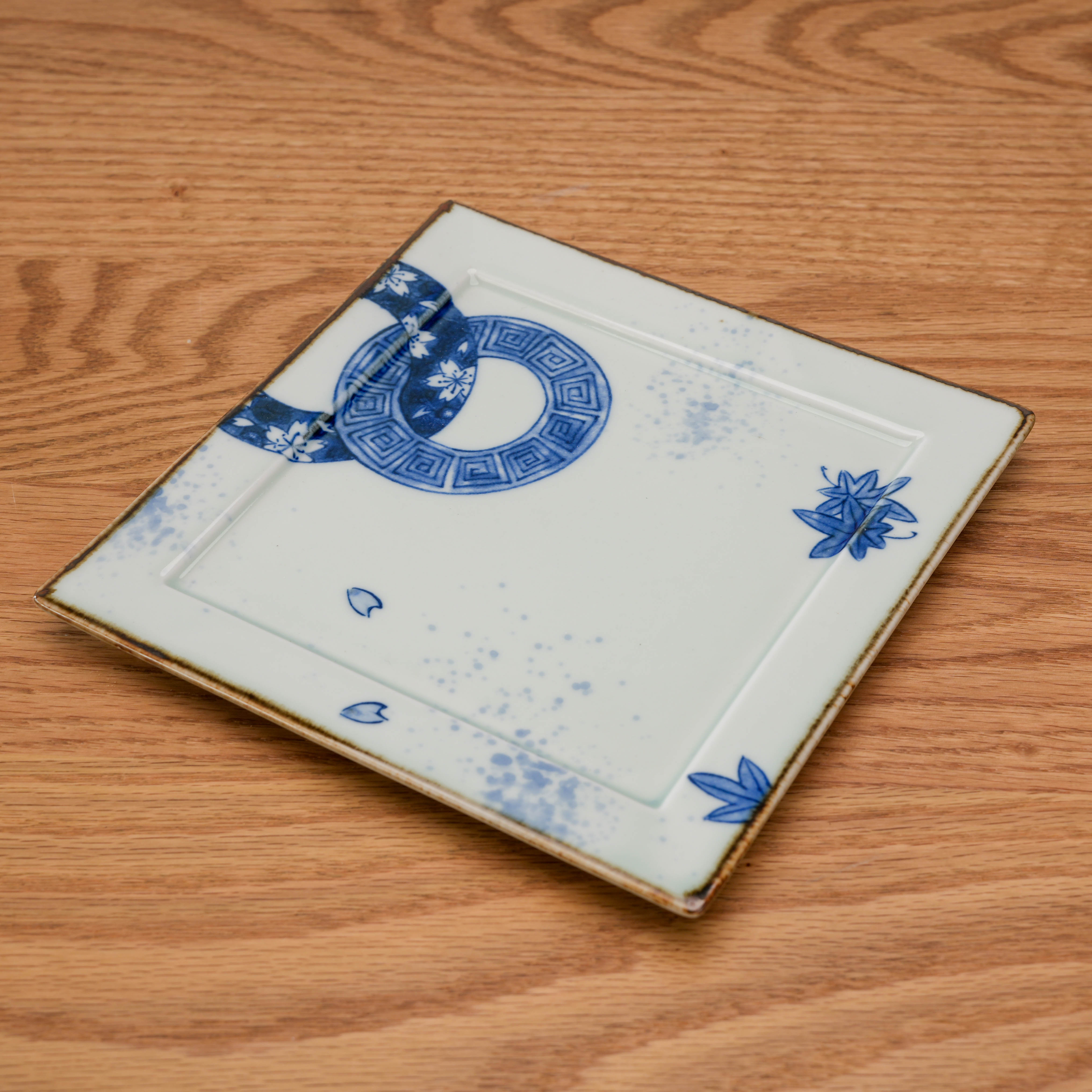 Hand-painted Mino Ware blue and white square plate featuring seasonal crest design, perfect for elegant table settings and modern dining.