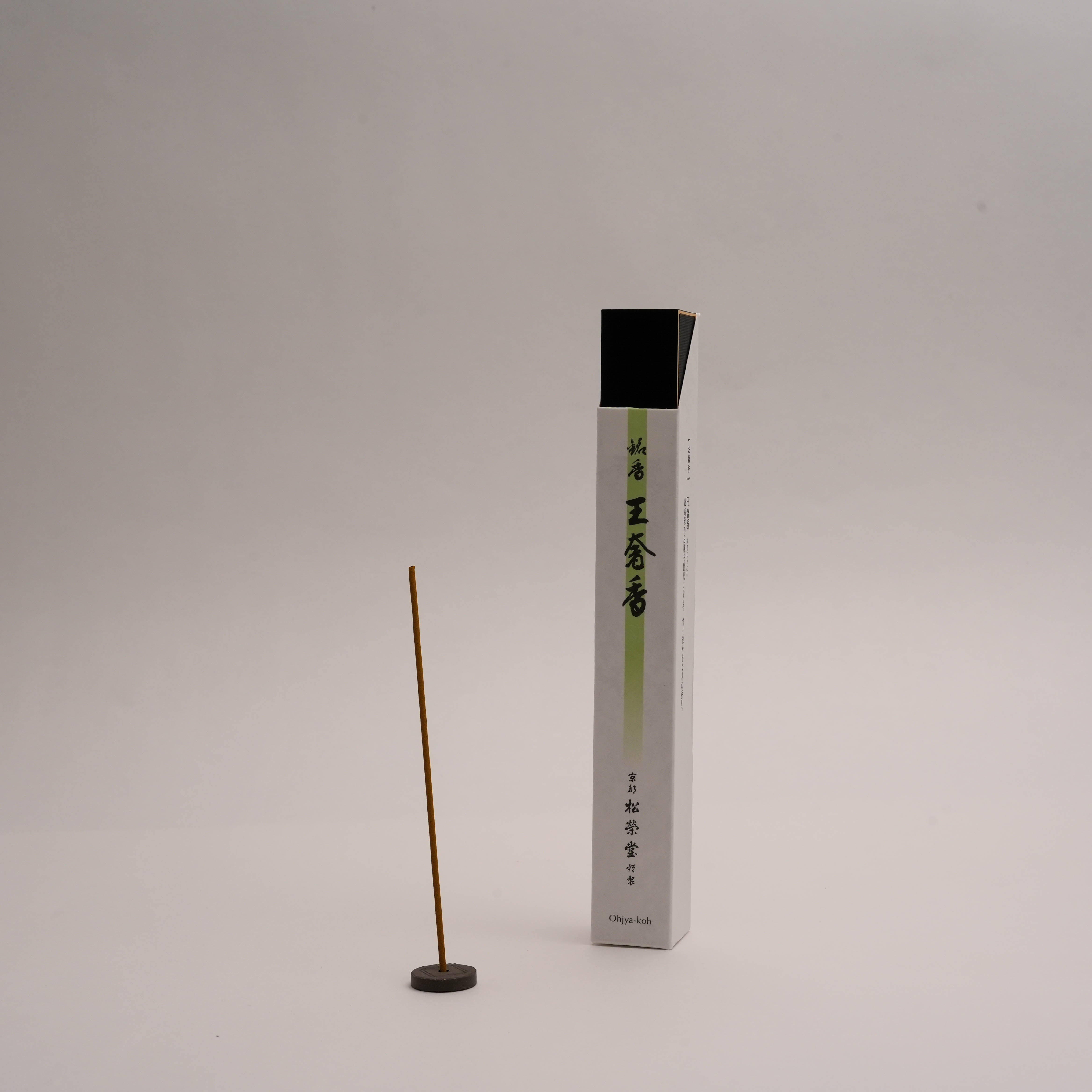 Shoyeido Incense - Ohjya-koh Aroma stick burning upright with box; features sandalwood, clove, and patchouli for home fragrance rituals.