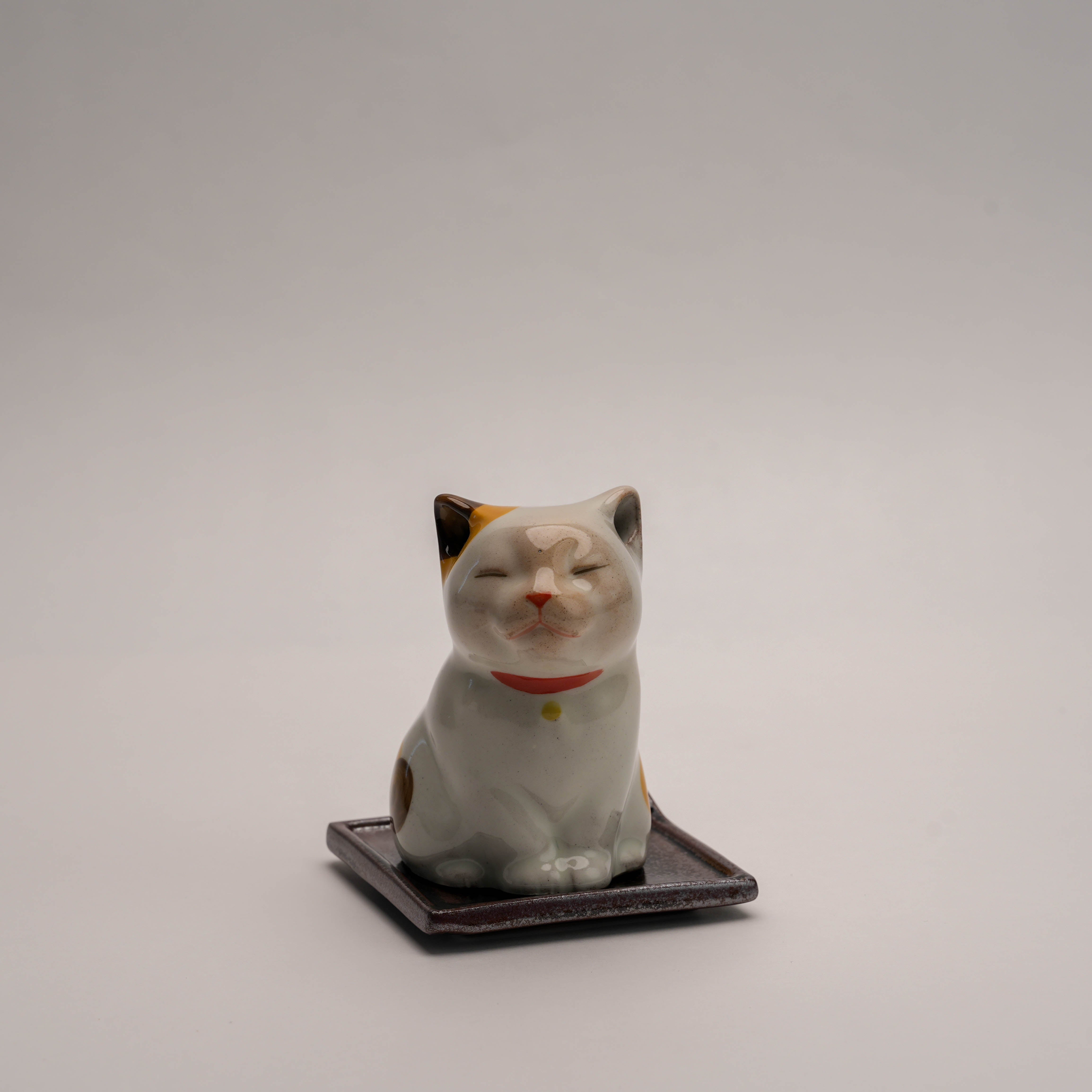 Shoyeido Cat Incense Burner with a smiling ceramic cat figure on a square tray, ideal for cone or stick incense use in home decor.