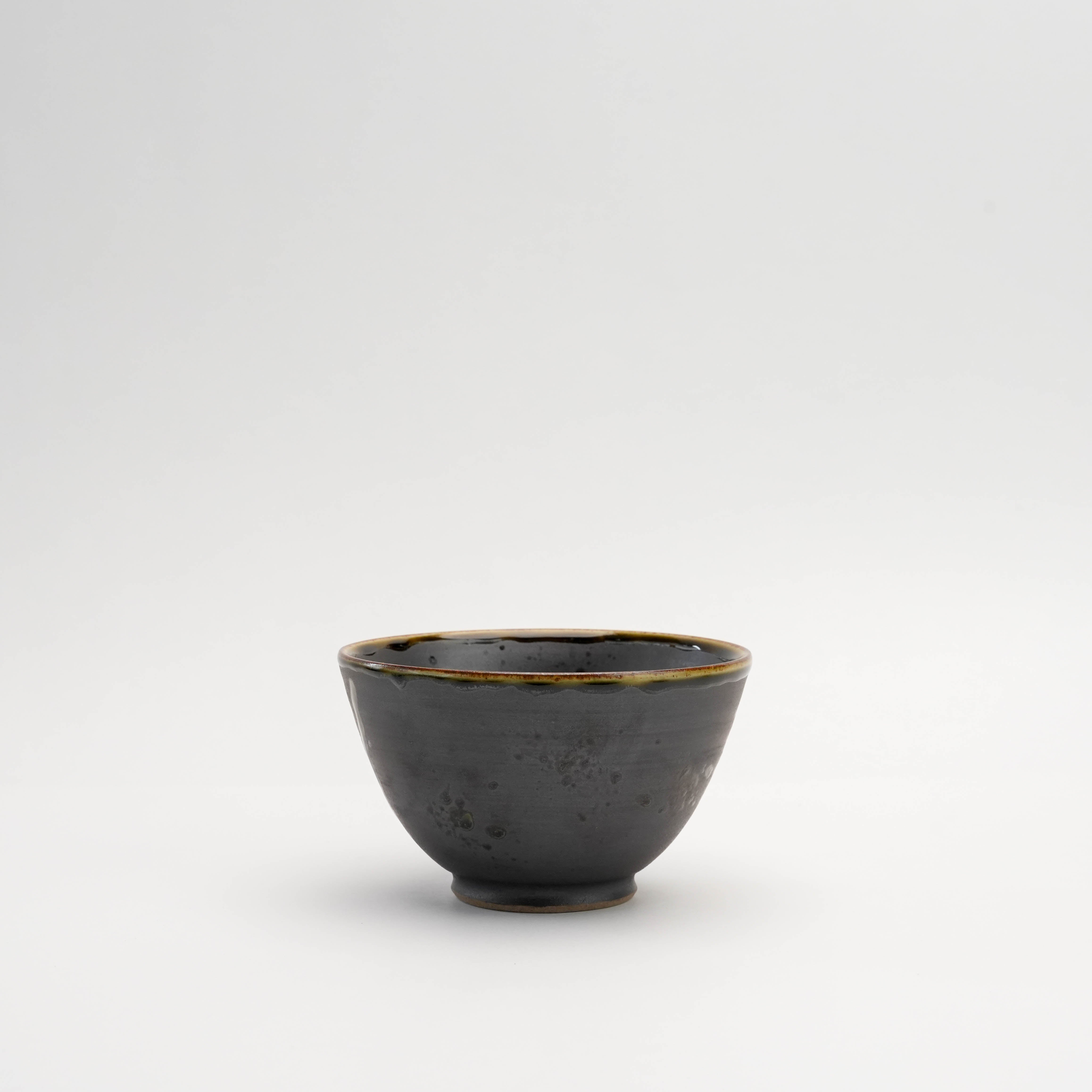 Side view of Arita Ware Fukukasu Black Rice Bowl showcasing its smooth matte finish and handcrafted ceramic texture in minimalist style.