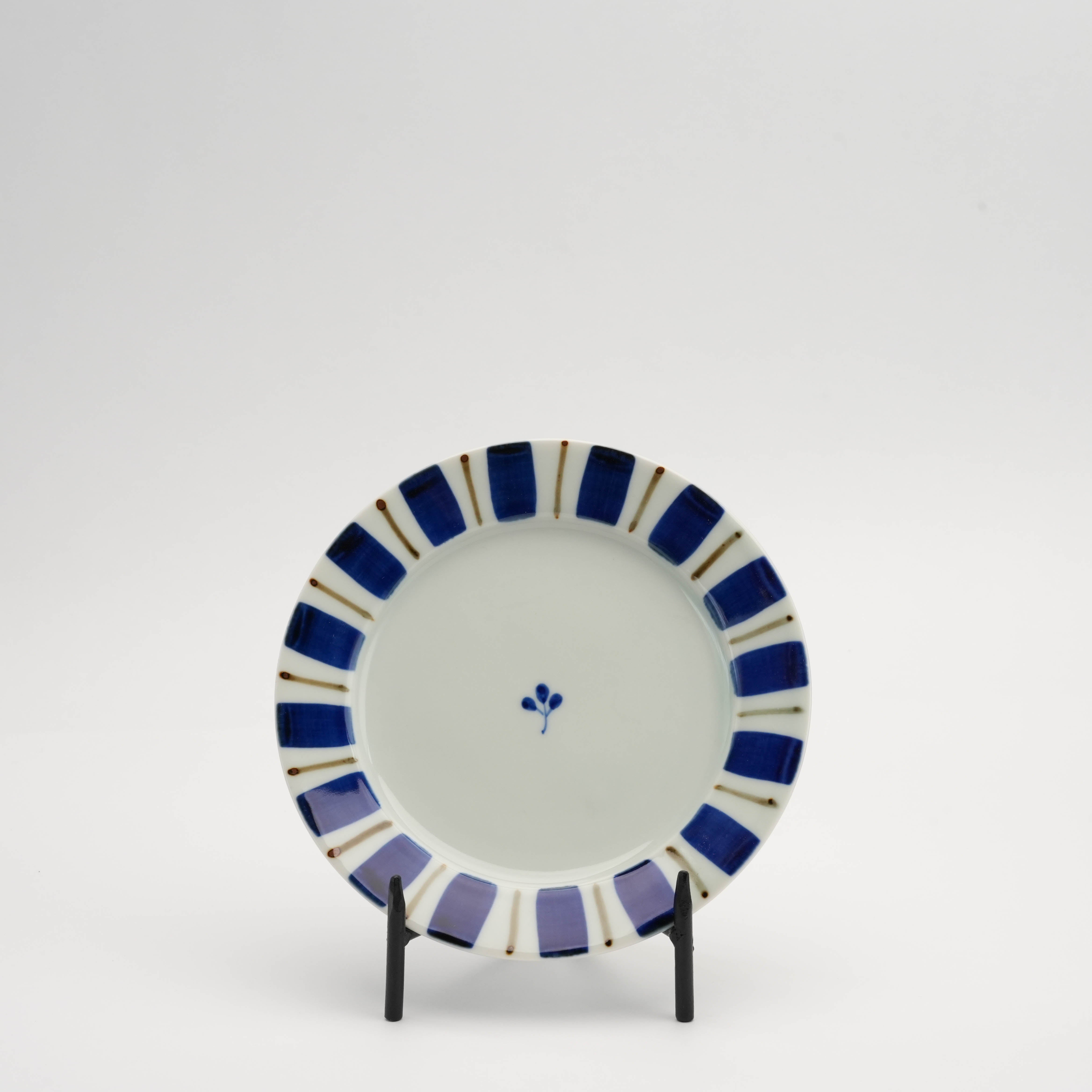 Arita Gosu Plate - Tokusa Design φ15.5cm displayed upright with bold blue radial stripes and minimalist floral center, ideal for desserts.