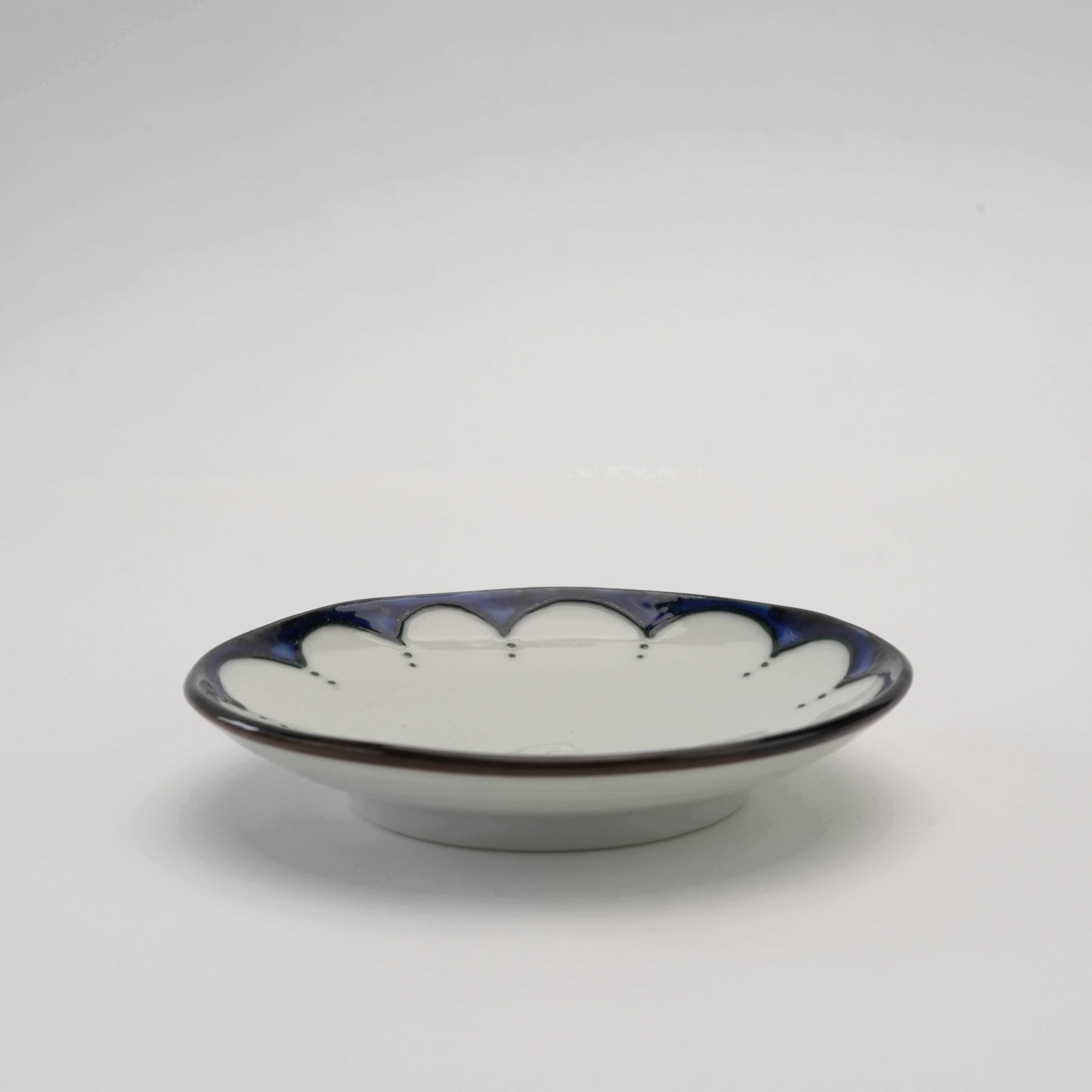 Side view of Arita Ware Edo Floral Dot Pattern Small Plate showing shallow depth and elegant indigo border, perfect for stylish dining settings.