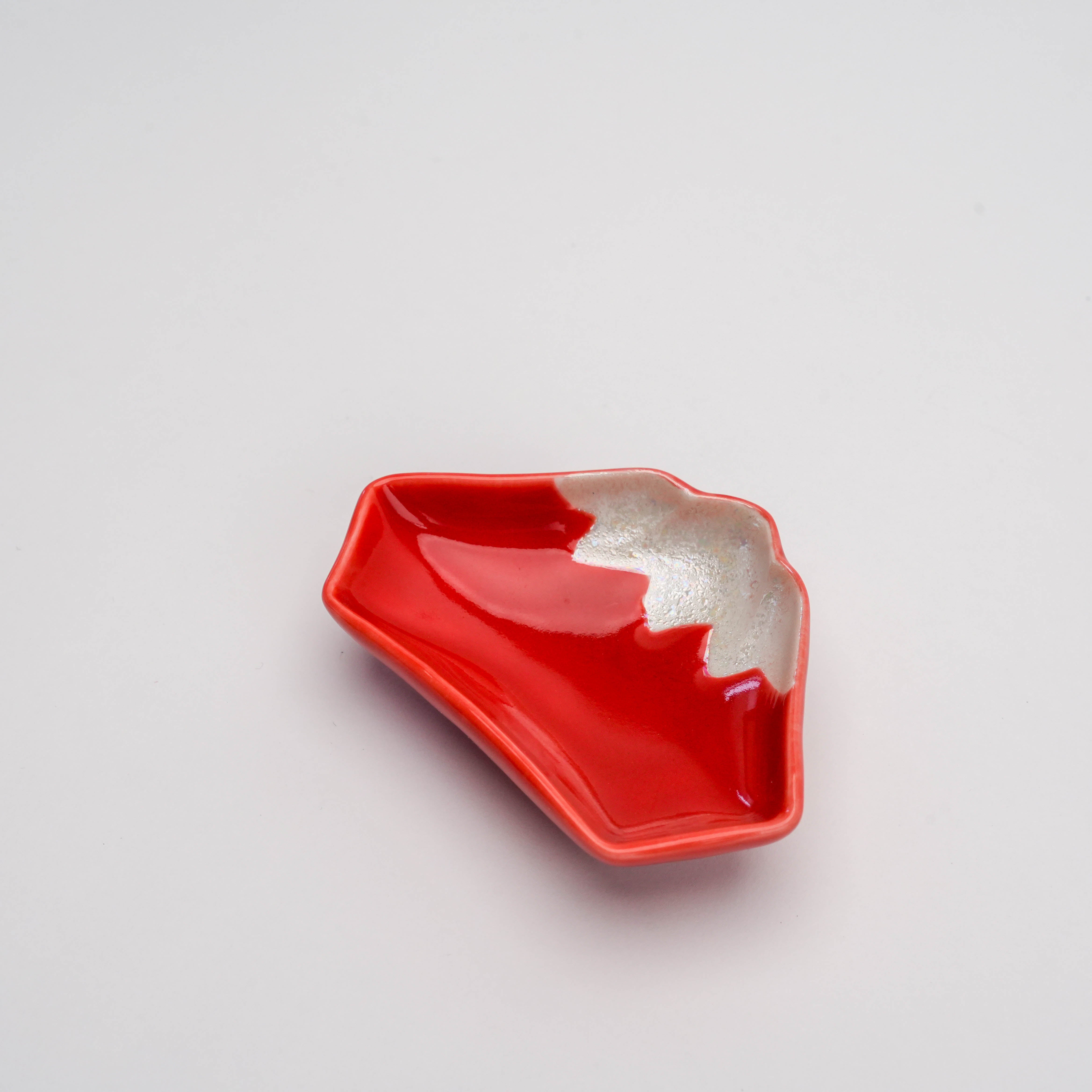 Angled view of Arita Ware Red Mt. Fuji Small Dish showcasing its unique mountain shape and glossy red glaze for stylish condiment serving.