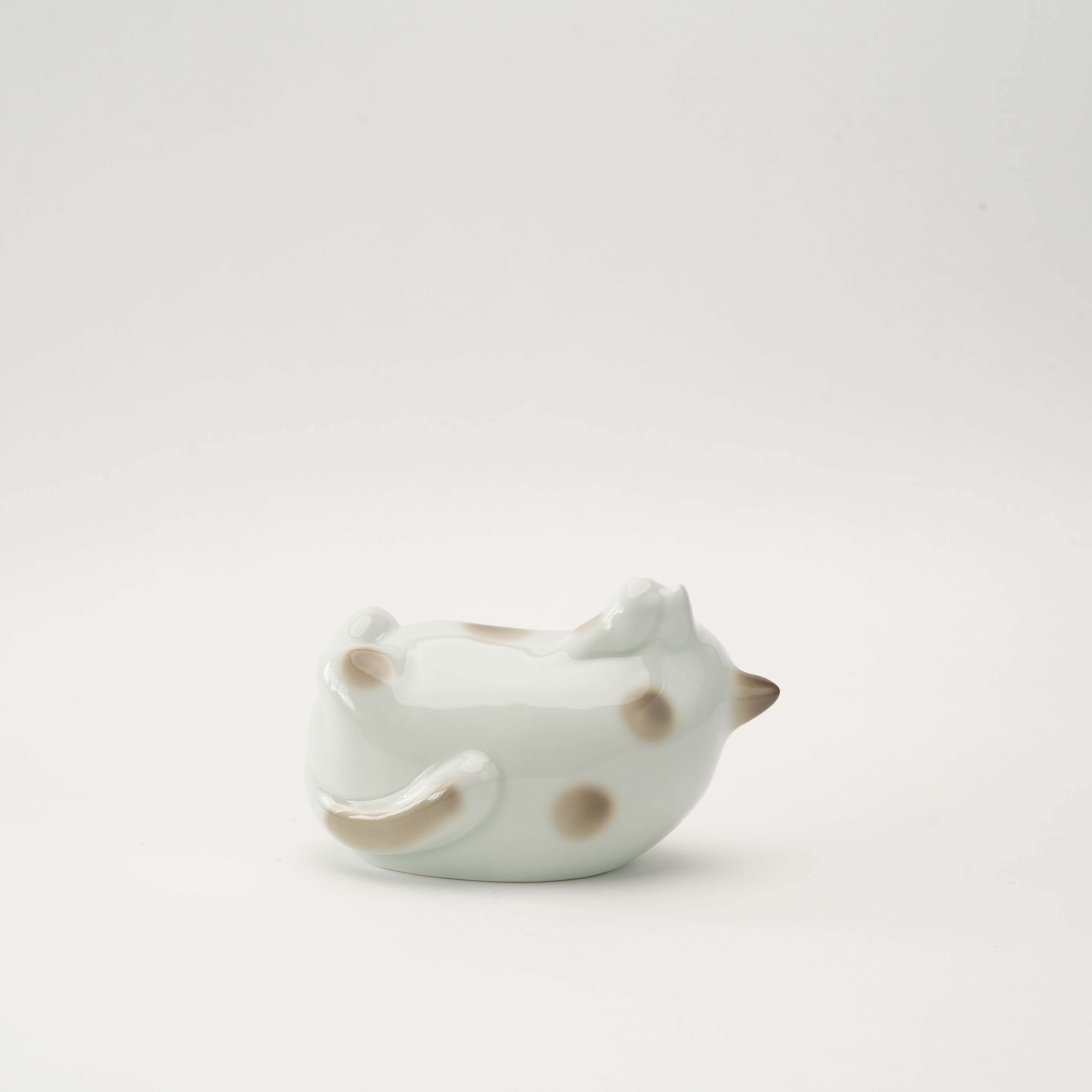 Back view of the Arita Ware Laughing Cat Ornament in soft brown porcelain, showcasing hand-painted details and curled tail design.