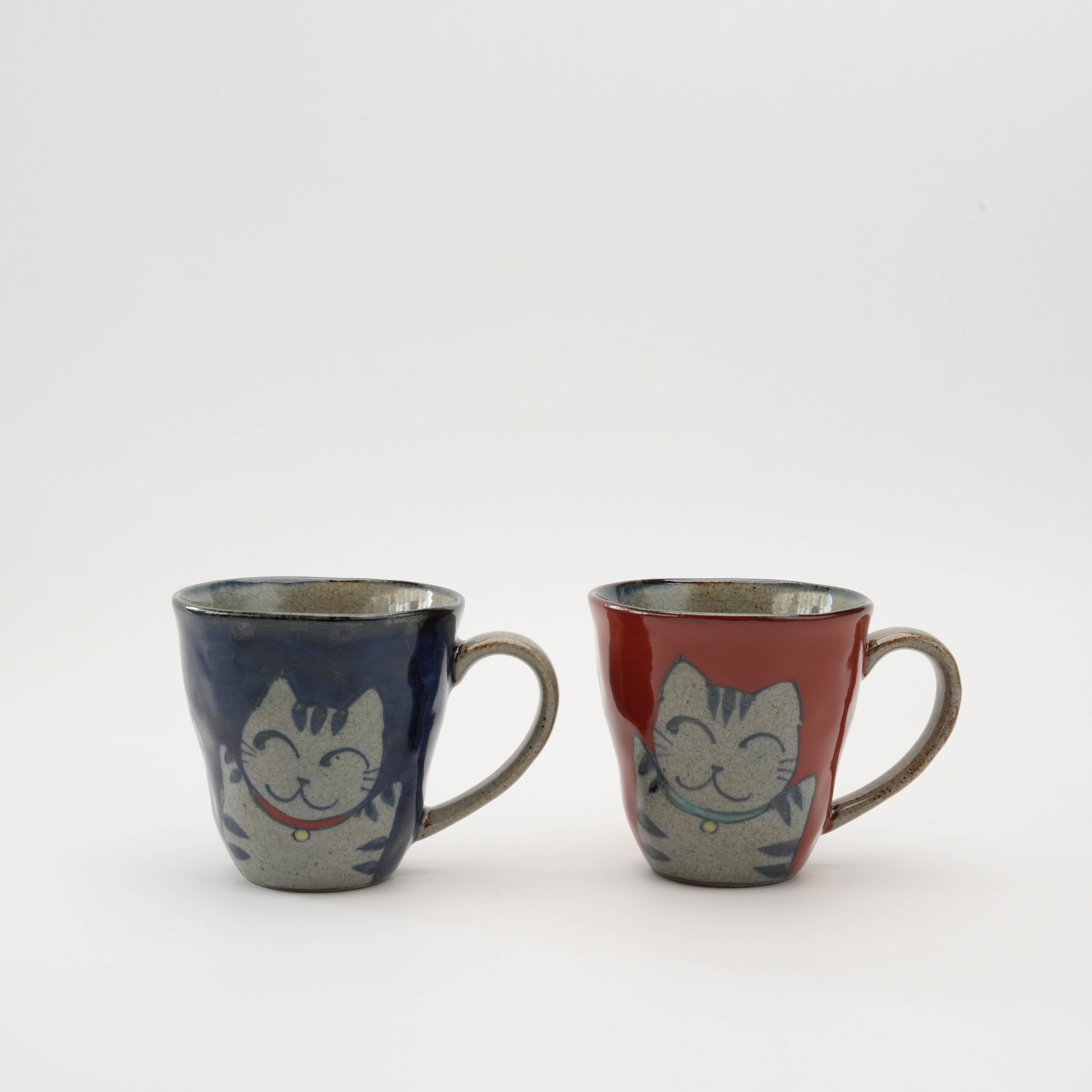 Arita Ware Lucky Cat Pair Mugs in blue and red with smiling cat design, ideal for Japanese-style drinkware in kitchen or dining decor.