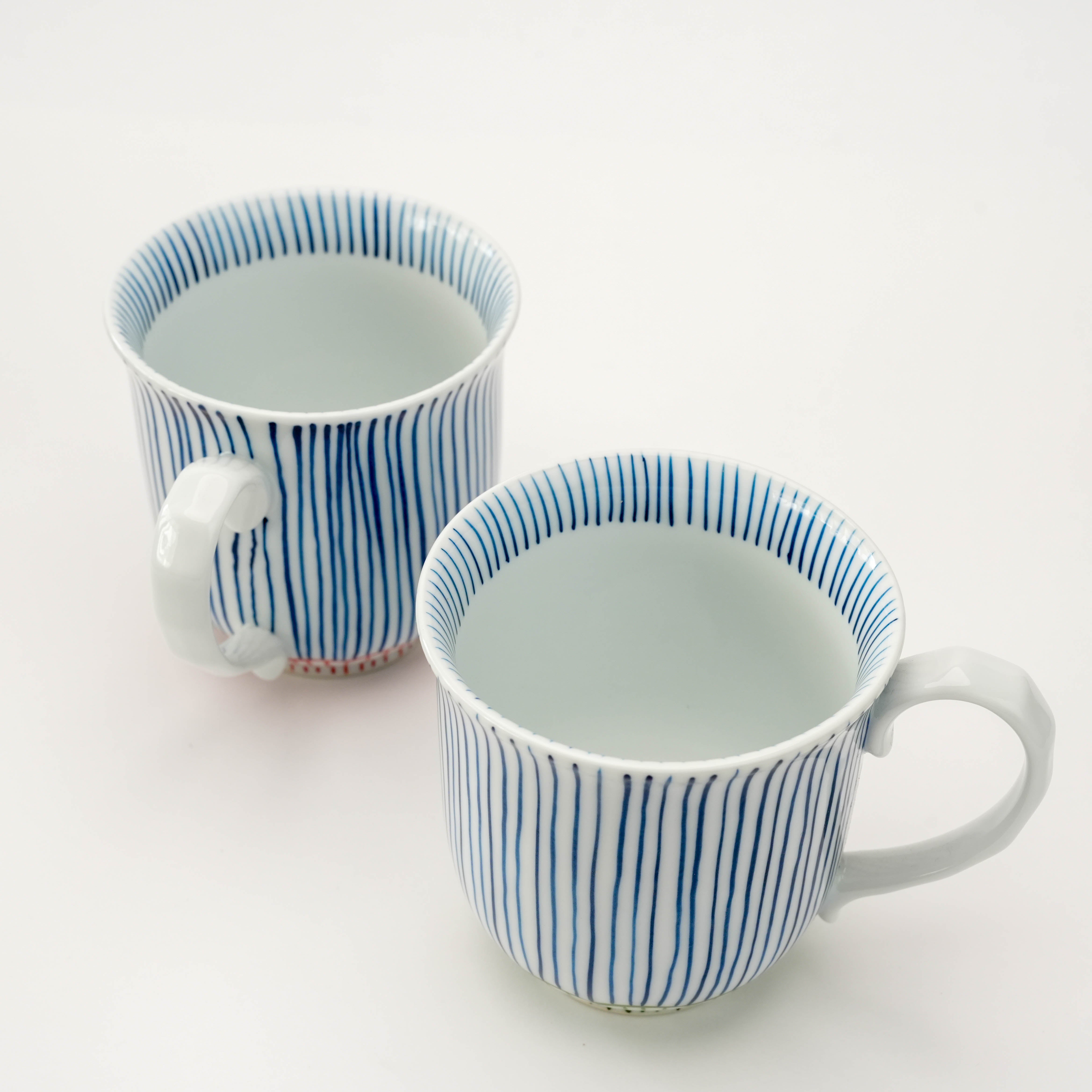 Top view of Arita Ware Nishoku Tokusa Pair Mug Set showing fine blue stripe detailing and elegant curved handles, ideal for tea or coffee.