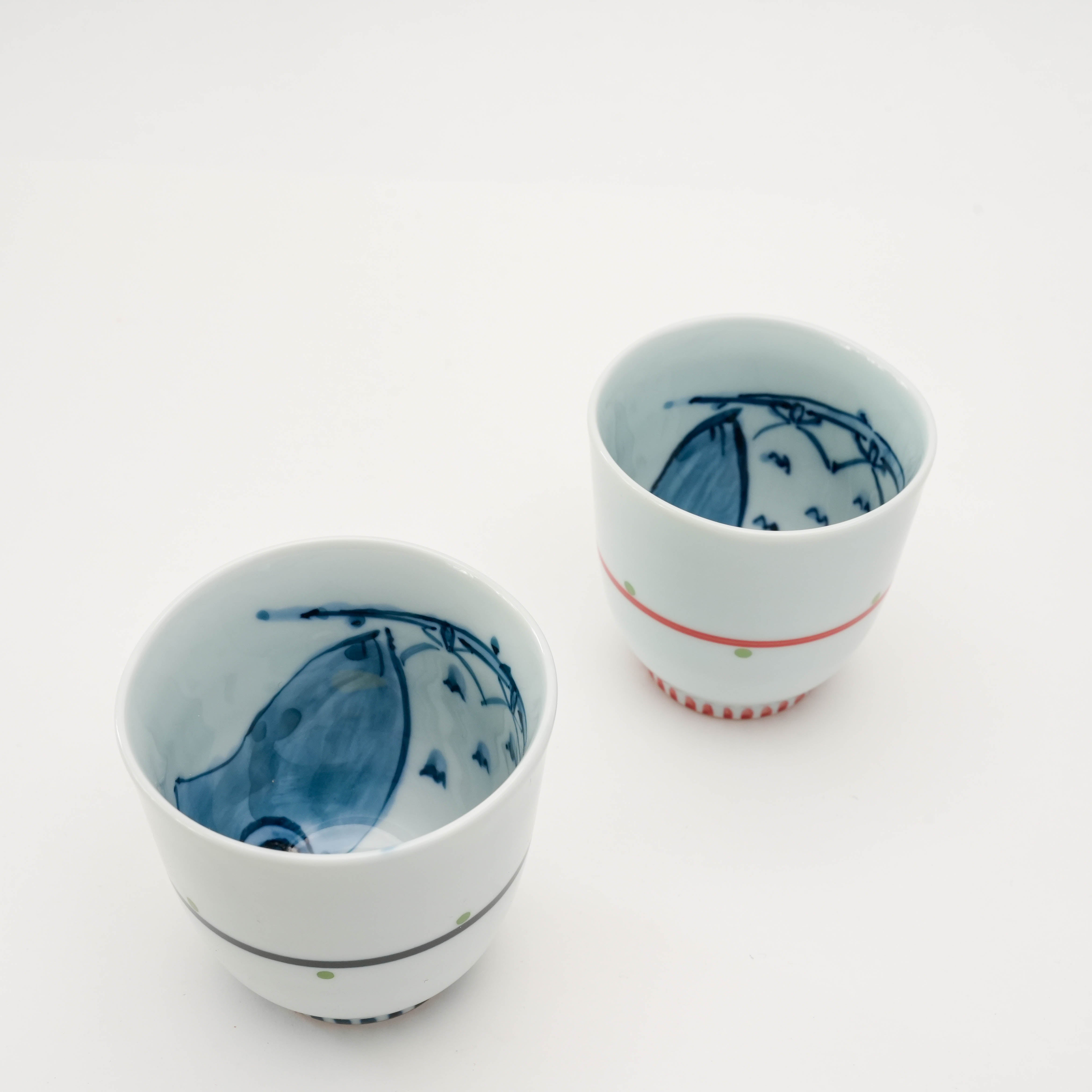 Top view of Arita Ware Owl Teacups showing hidden owl illustrations inside. Fun Japanese porcelain mugs in red and navy styles.