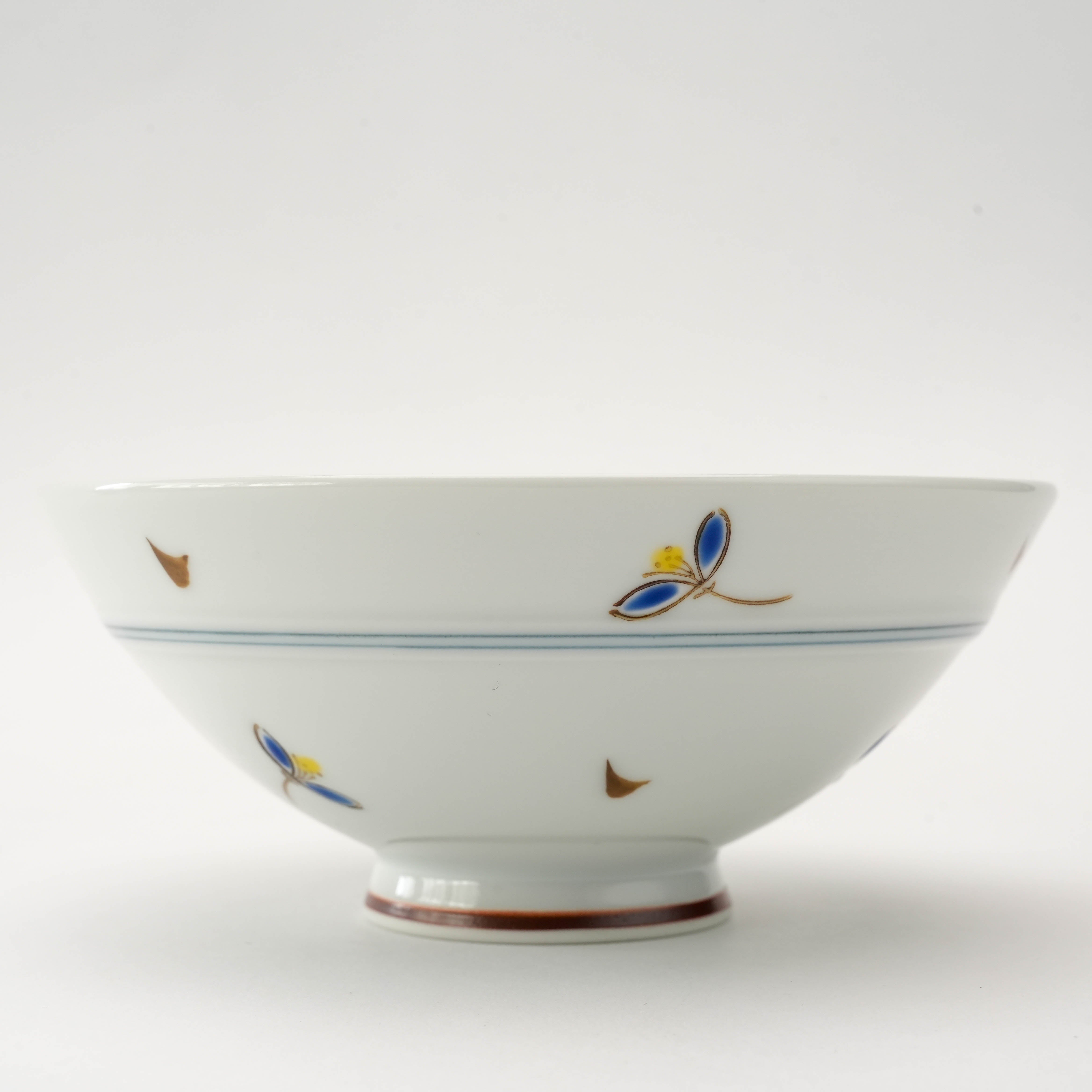 Close-up of Arita Ware Akane Grass Rice Bowl showcasing delicate blue and gold hand-painted petals and fine porcelain craftsmanship.