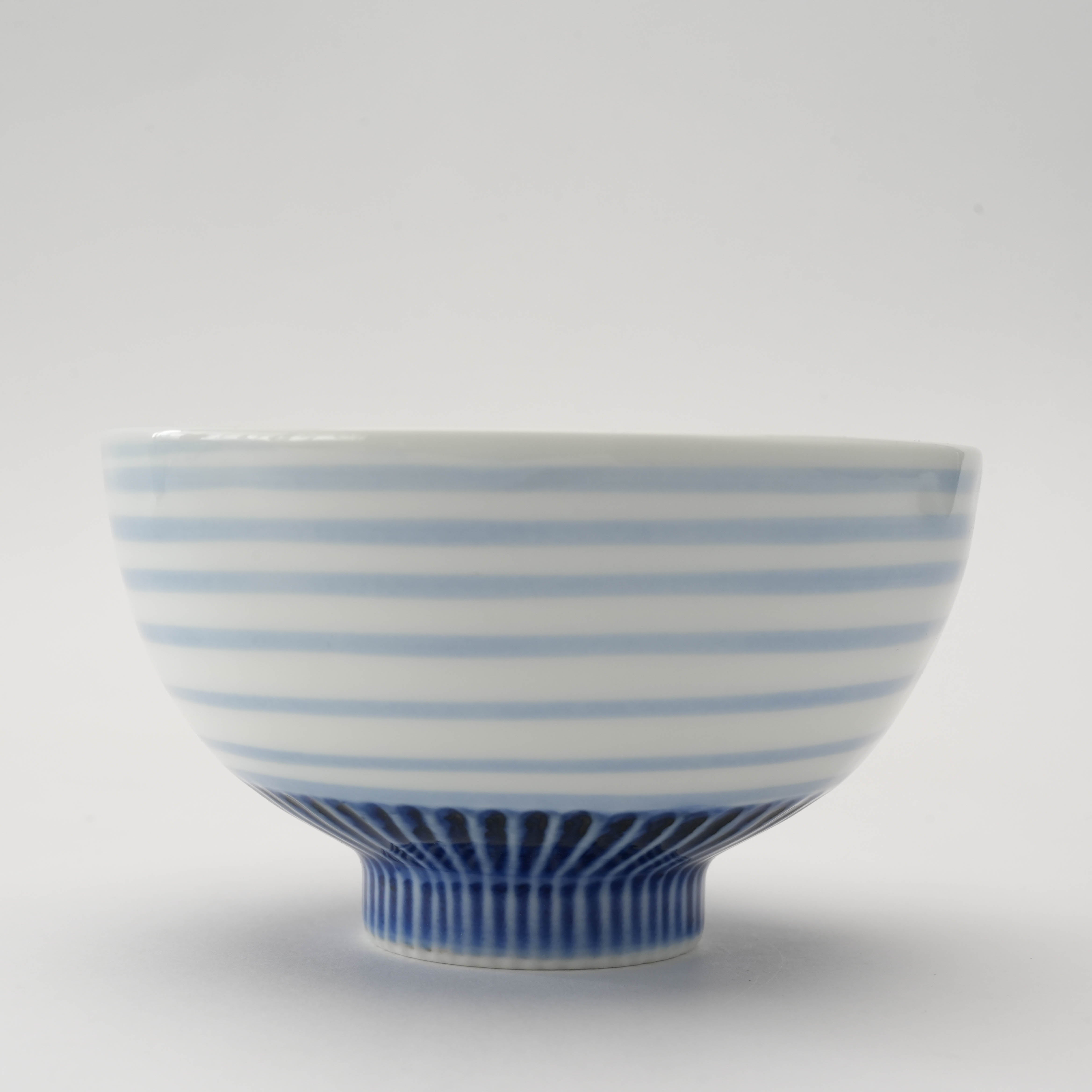 Side view of Arita Ware Medaka Fish Rice Bowl showcasing horizontal indigo stripes and refined craftsmanship, perfect for modern kitchen decor.