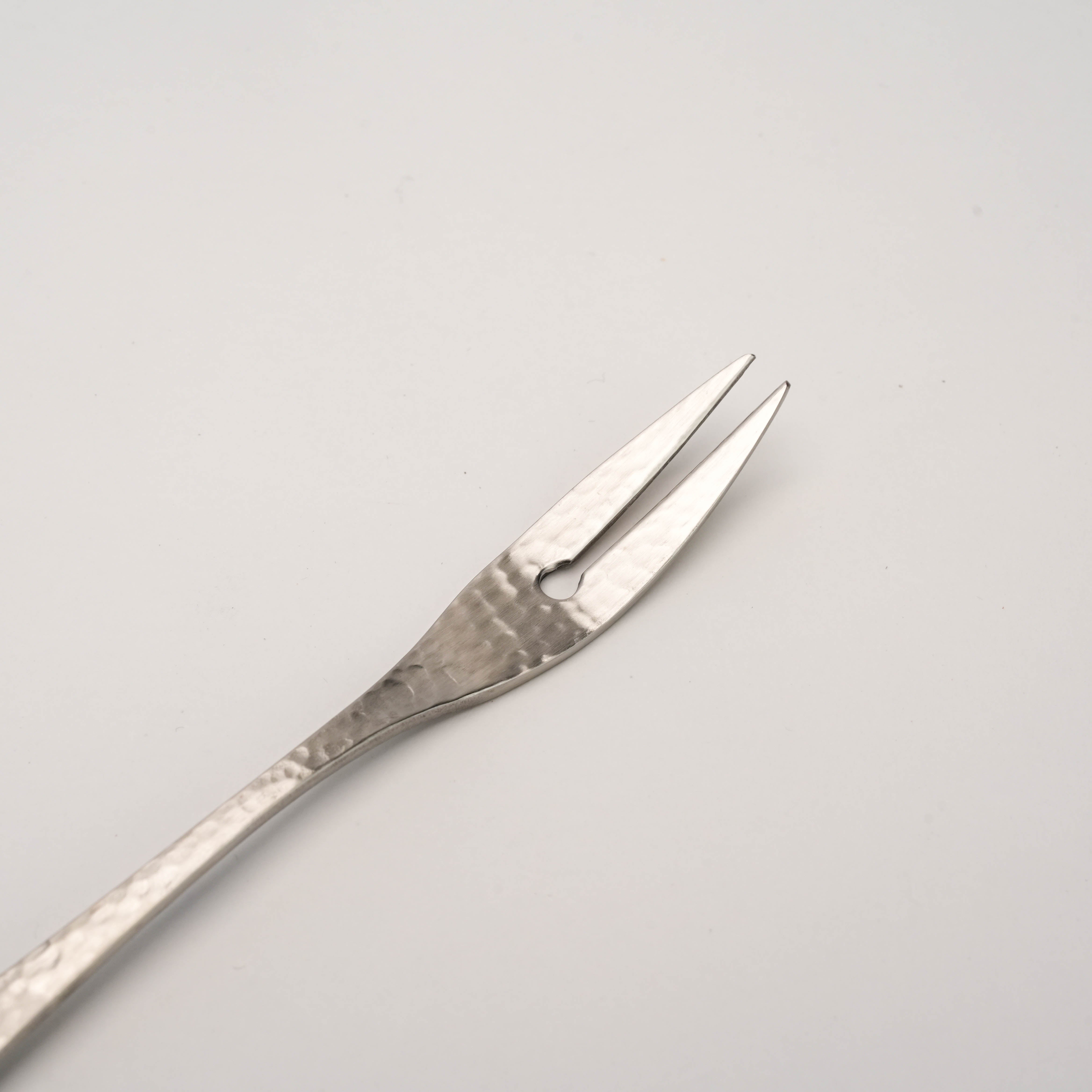 Close-up of Tsubamesanjo Nagomi Wafu Fork showing hammered texture and dual prongs, crafted for refined dining and cocktail tool collections.