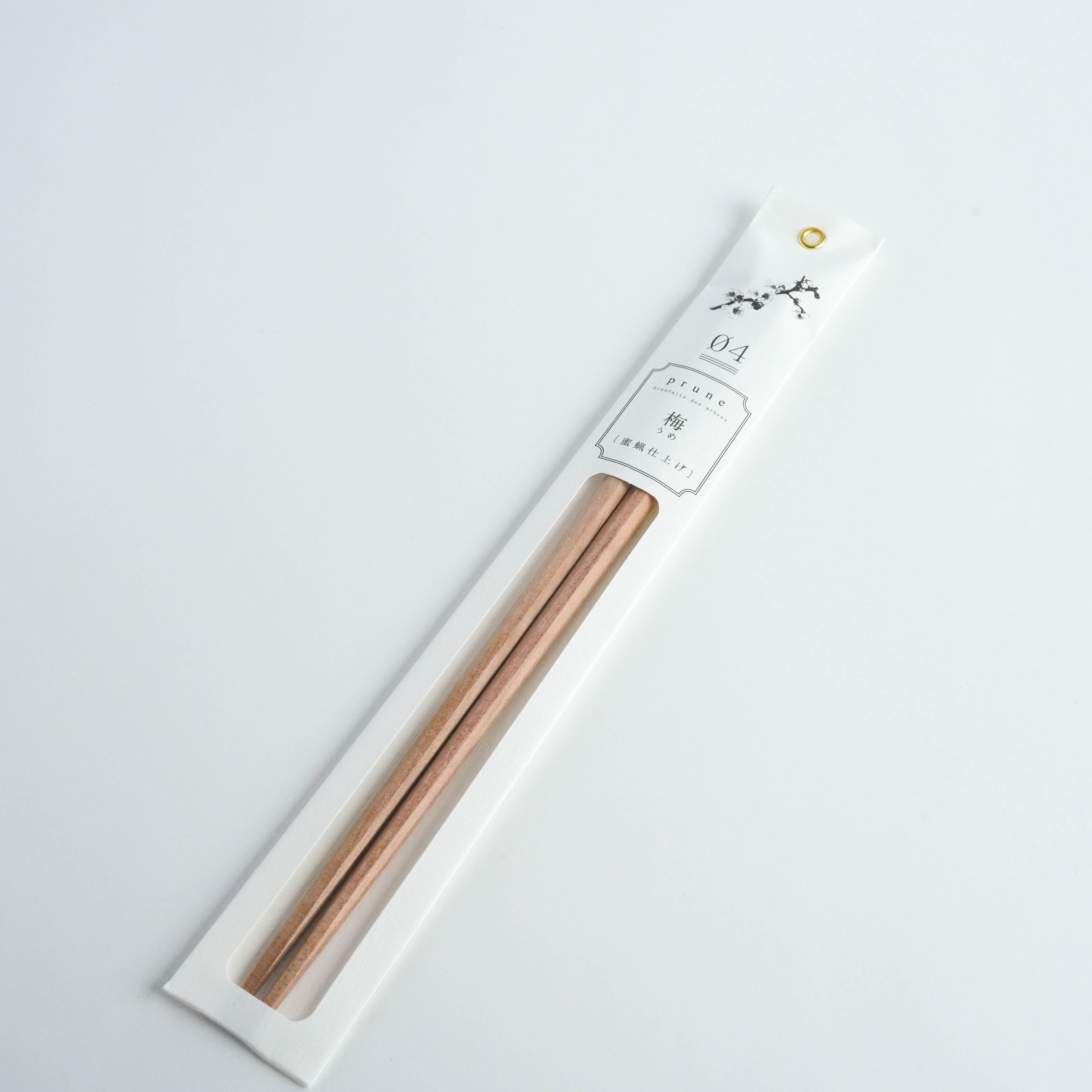 Kawai Tetoca Chopsticks in prune wood with beeswax finish, packaged in elegant white sleeve with floral design, showcasing natural elegance.
