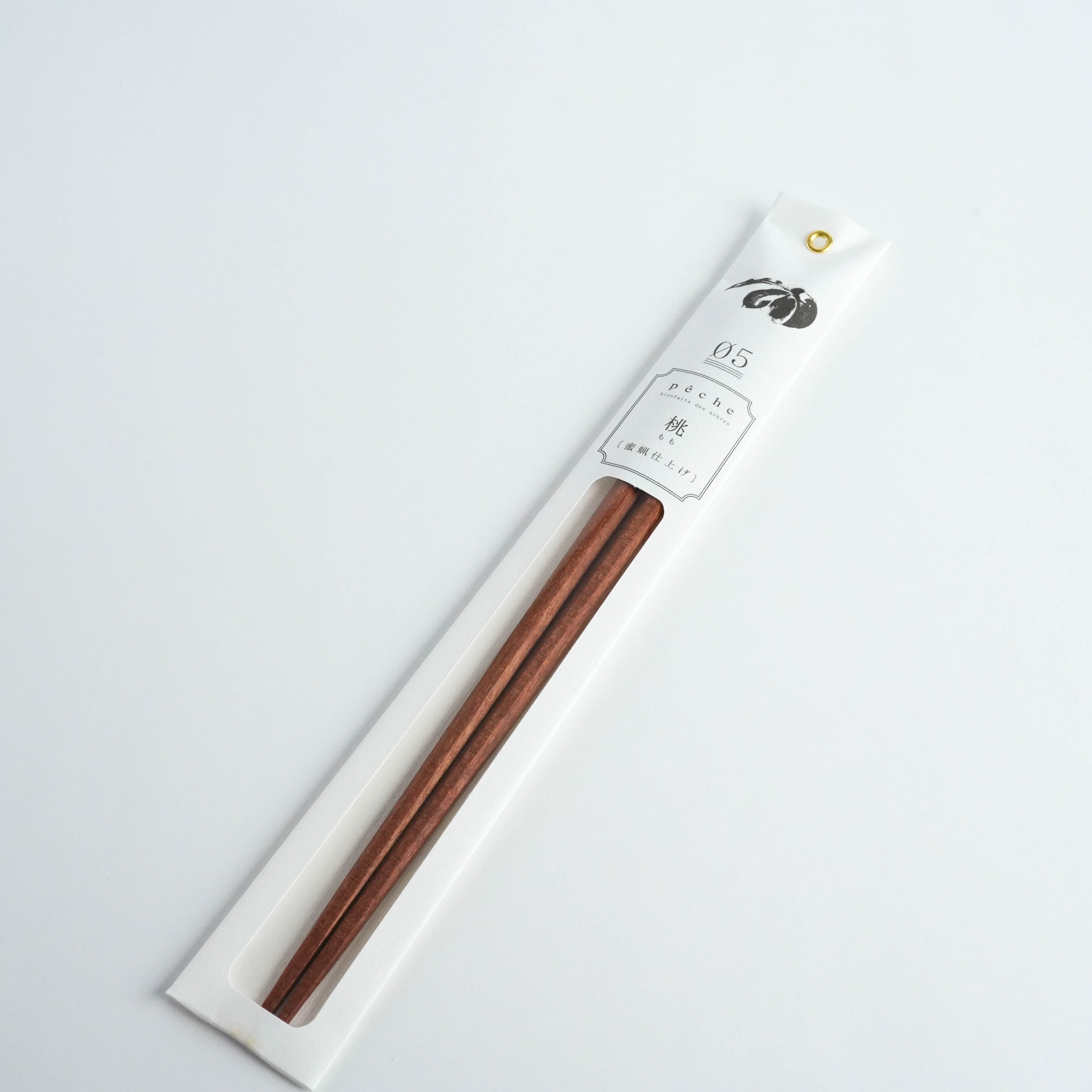 Kawai Tetoca Chopsticks - Peach Wood in minimalist white packaging with gold rivet, showcasing natural wood grain and beeswax finish.
