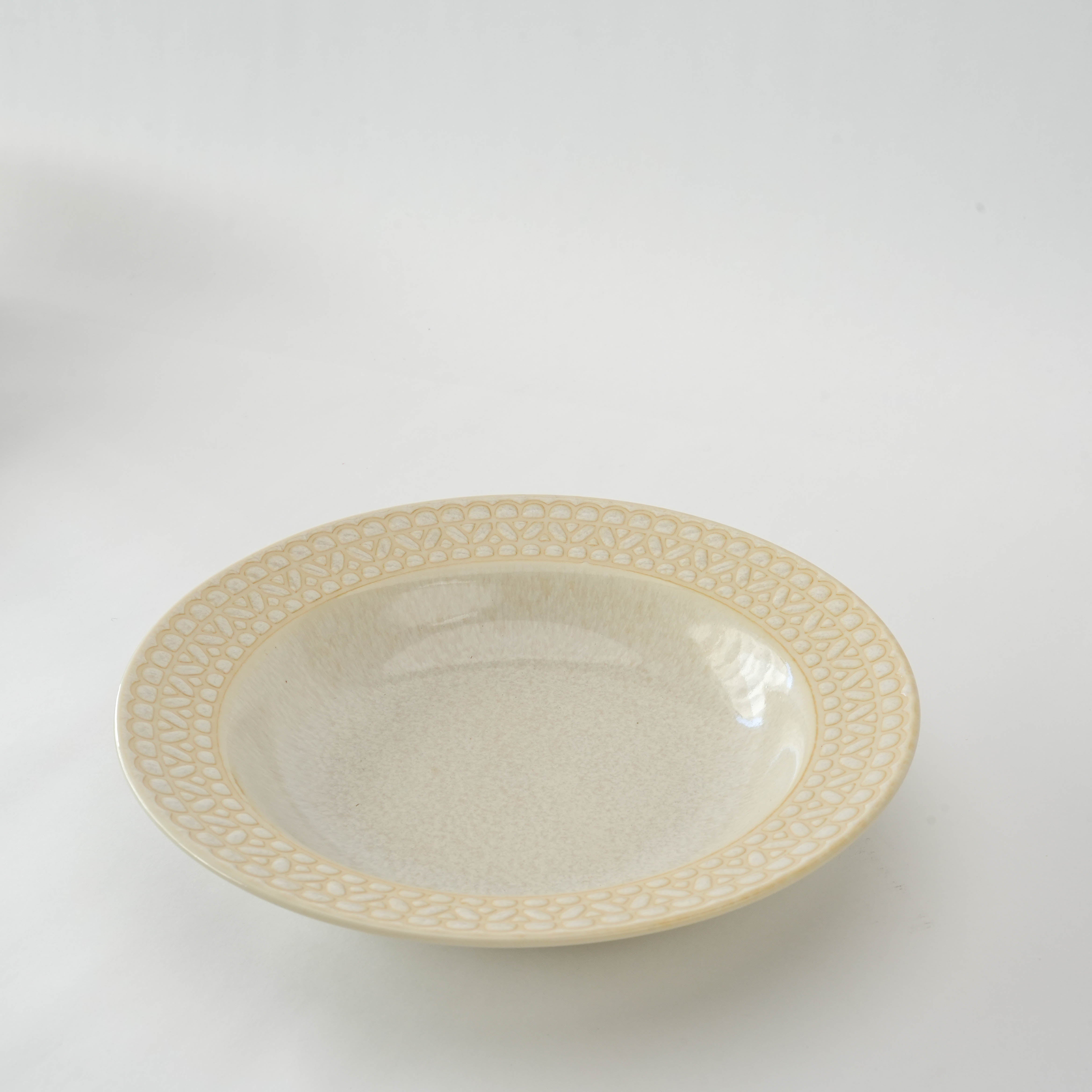 Side-angled view of Mino Ware Lace White Rim Coupe Plate, 23.5 cm, showcasing its shallow depth and intricate rim design for stylish table settings.