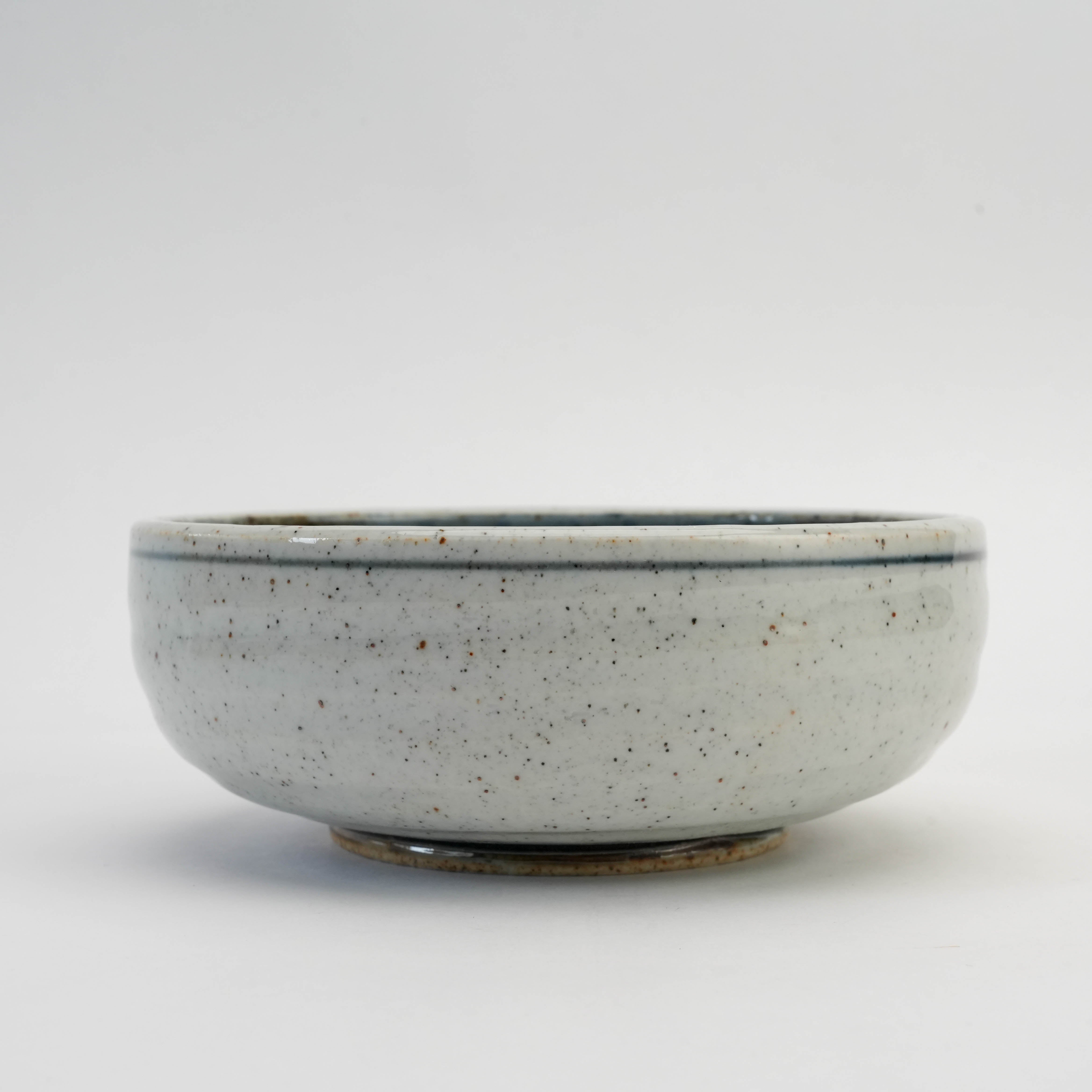 Side profile of Mino Ware Ishiyaki Bowl with speckled white exterior and subtle blue rim, ideal for elegant kitchen and dining decor.