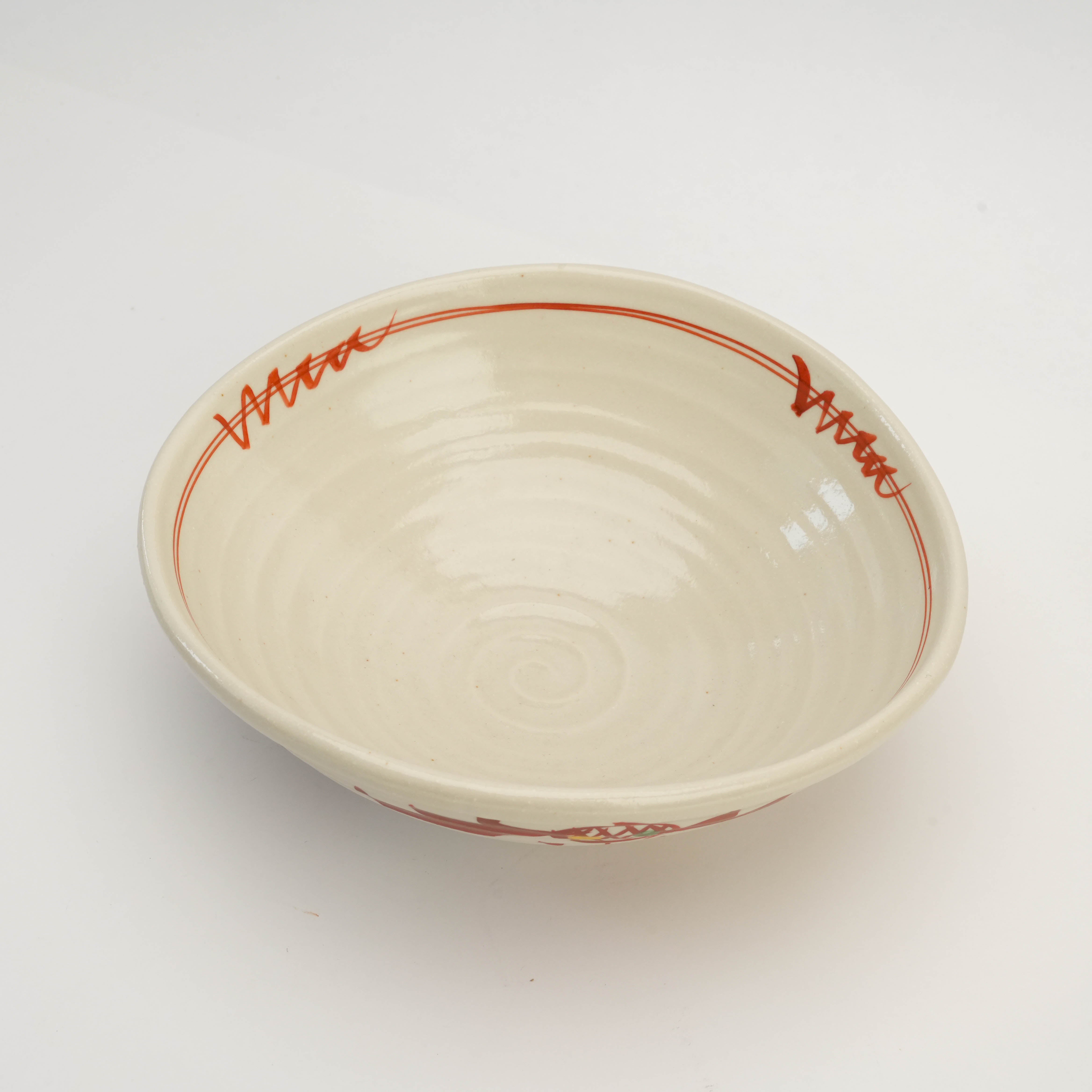 Top view of Mino Ware Kohiki Bowl with spiral interior and red brushstroke accents, designed for stylish presentation of meals.