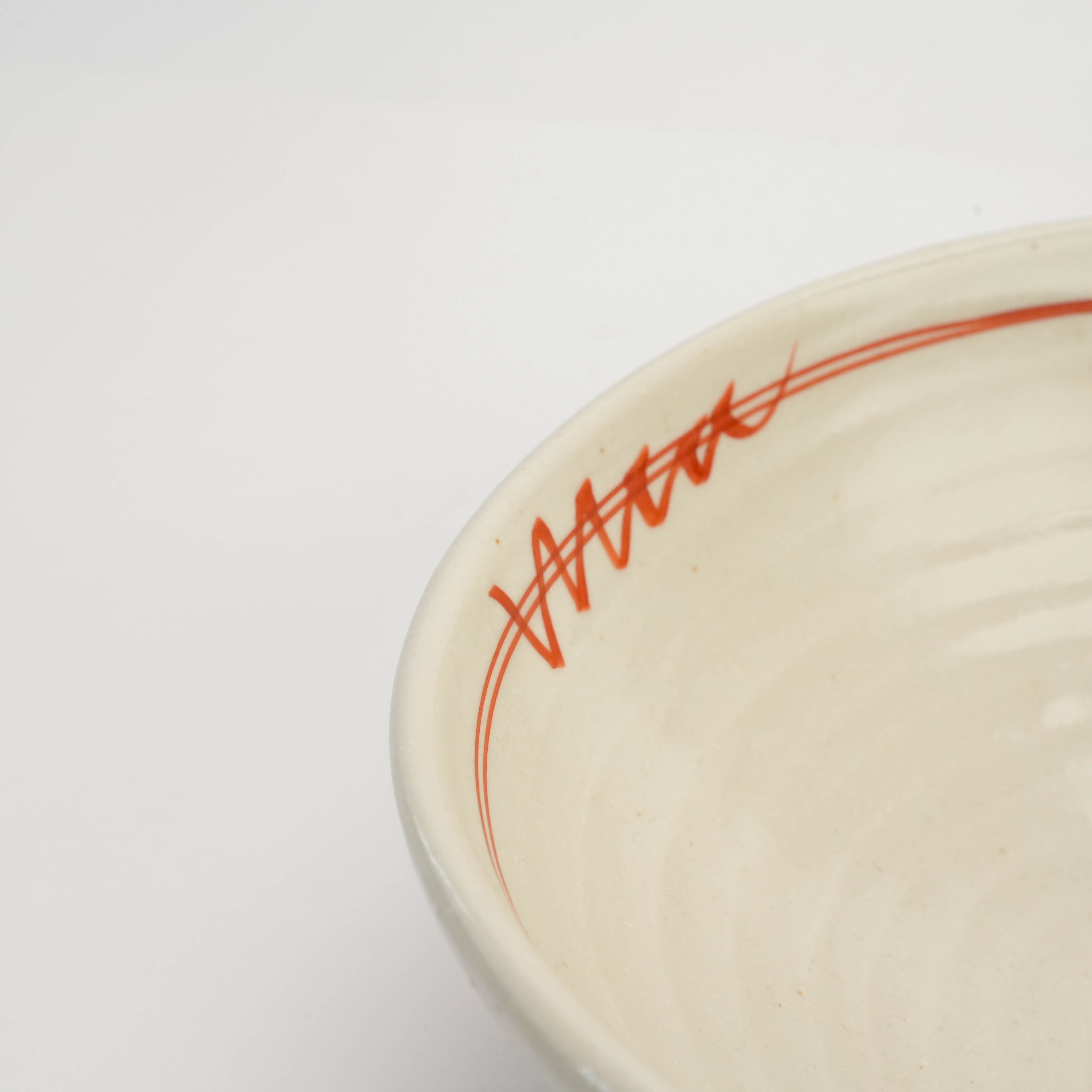 Close-up of Mino Ware Kohiki Bowl rim highlighting red akae brushstroke detail and smooth kohiki glaze finish for artisanal appeal.