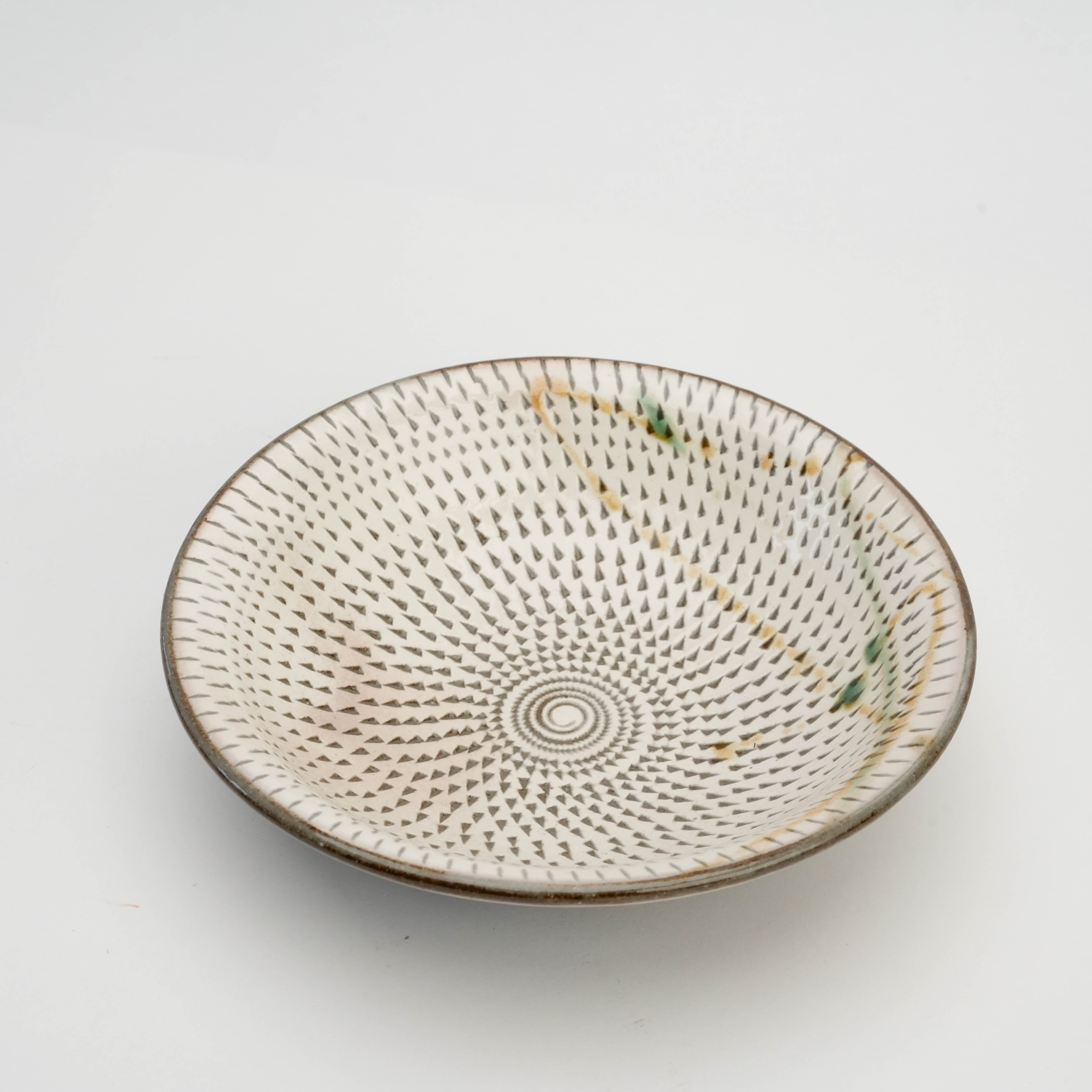 Top view of Mino Ware hand-carved Tobikanna bowl showcasing spiral and radial carvings in traditional Japanese ceramic design.