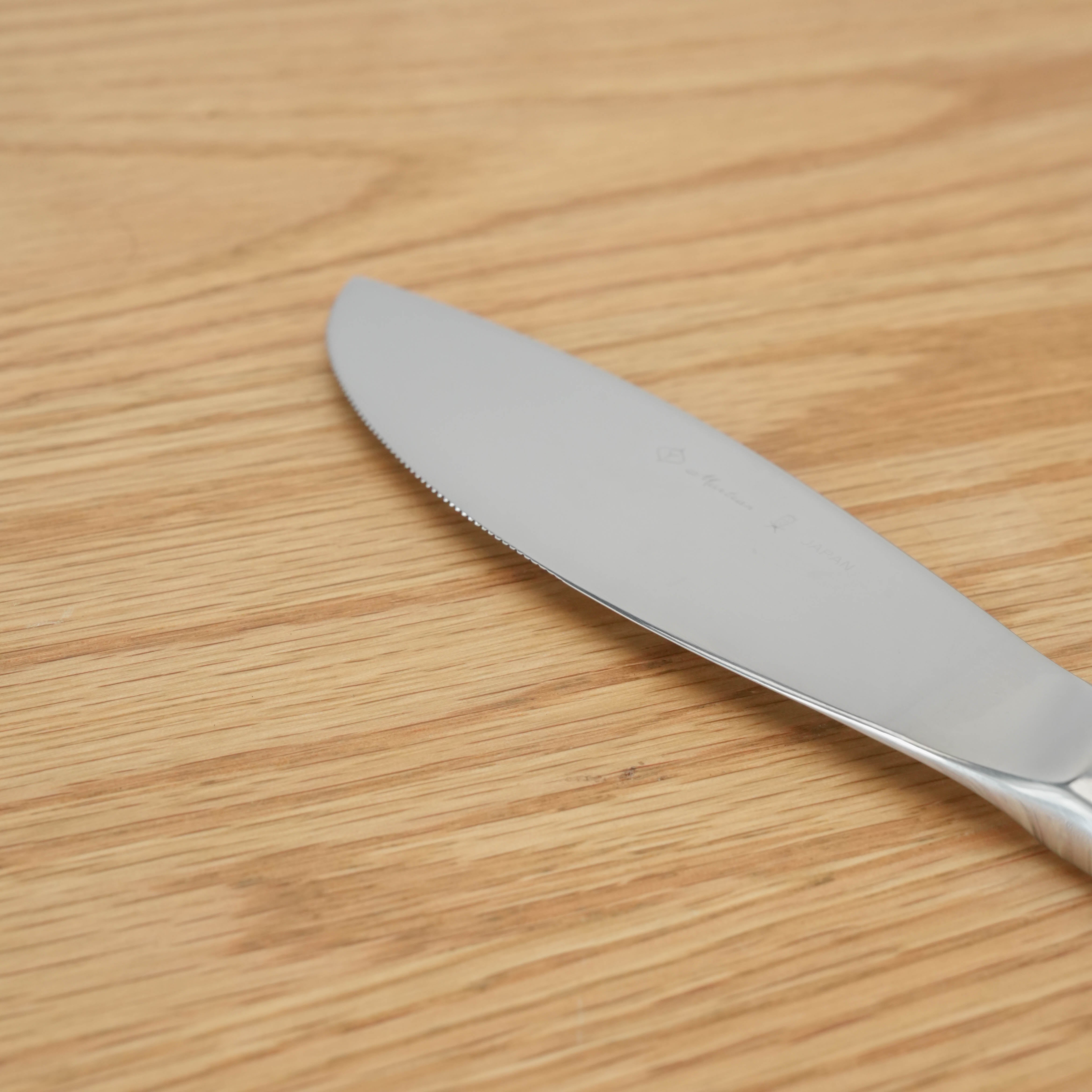 Close-up of Sori Yanagi Stainless Steel Dinner Knife showing fine serrated edge and polished finish. Balanced for precision and durability.