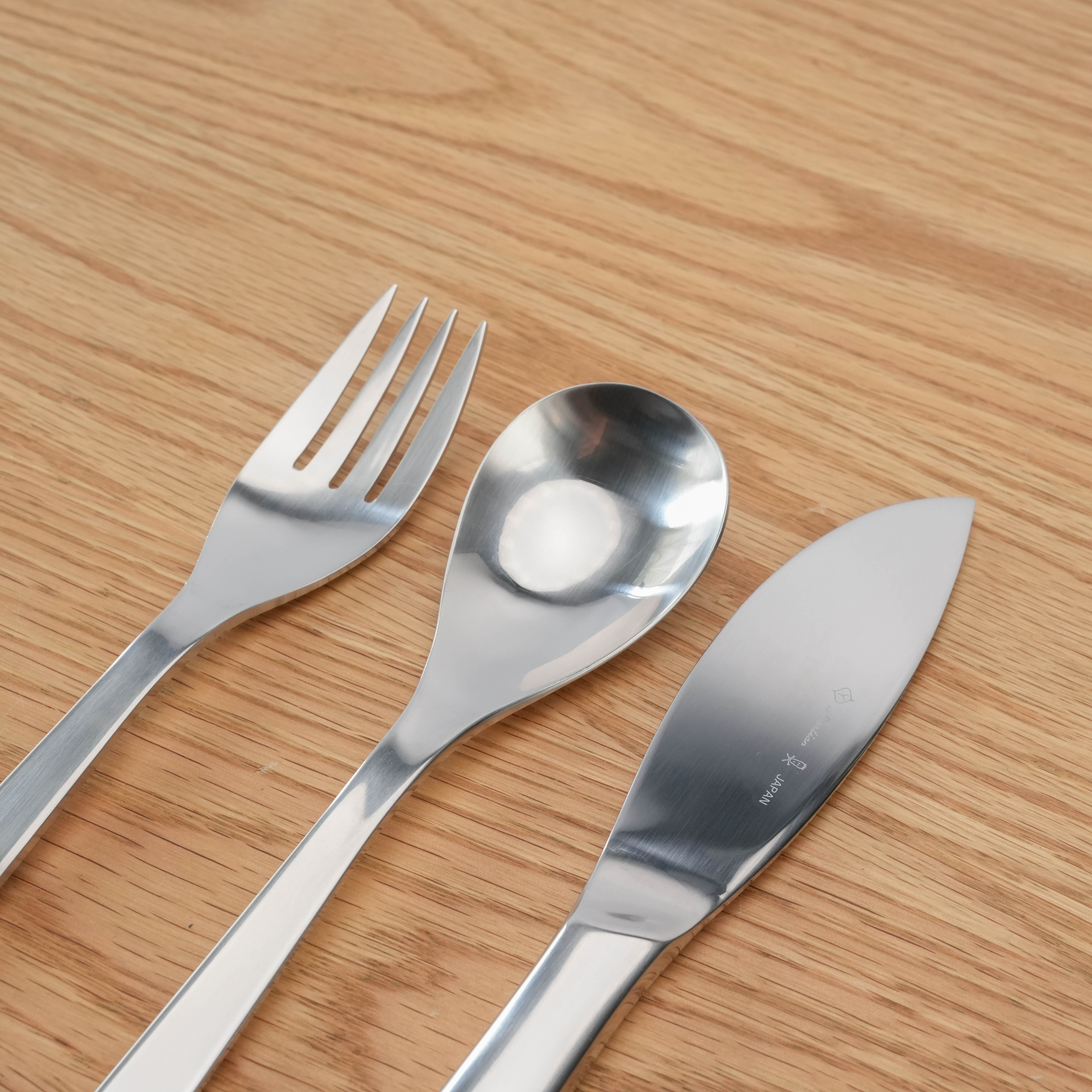 Close-up of Sori Yanagi Stainless Steel Dinner Cutlery Set showing minimalist design of knife, fork, and spoon. Ideal for stylish table settings.