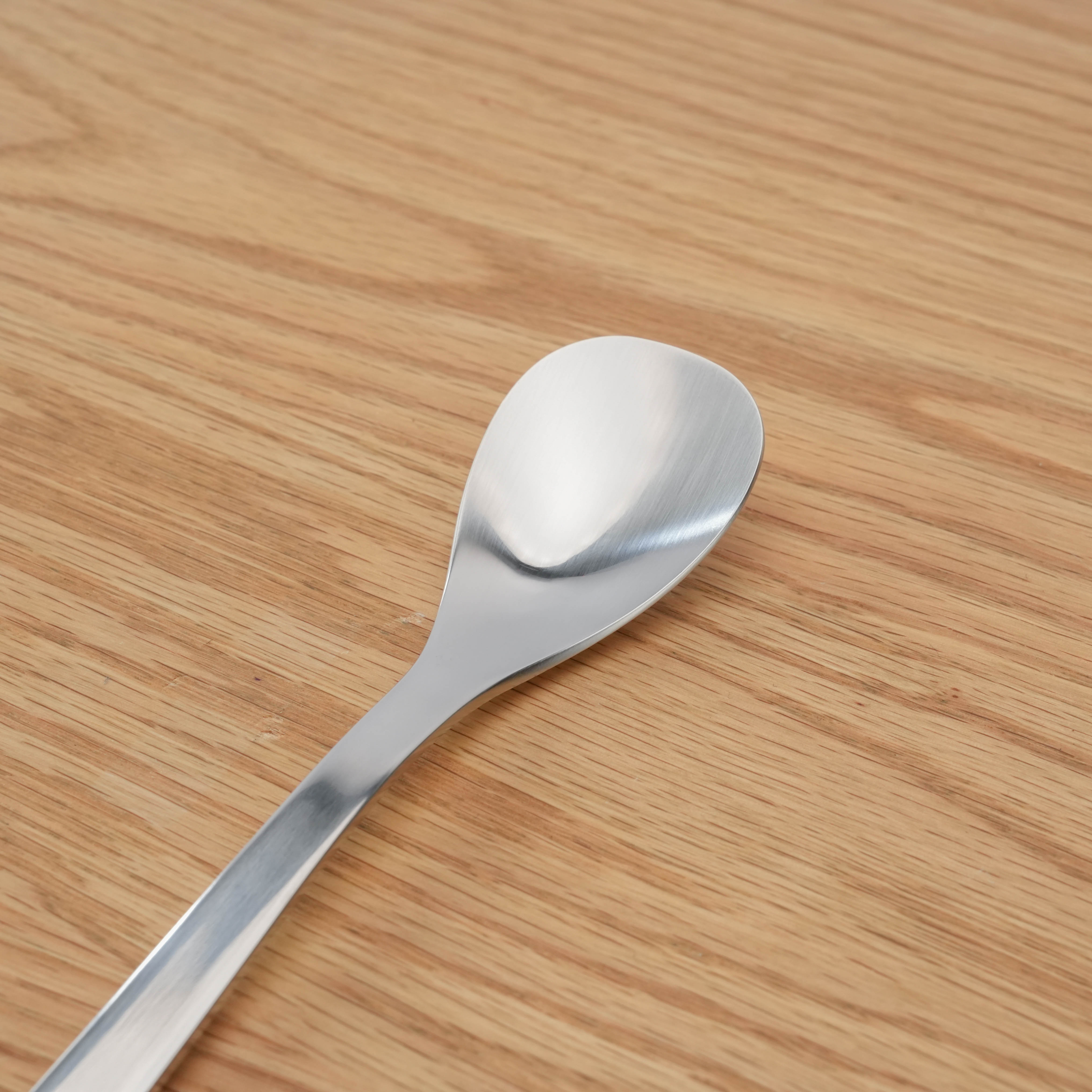 Close-up of Sori Yanagi stainless steel curry spoon head, highlighting smooth, brushed finish and ergonomic Japanese craftsmanship.