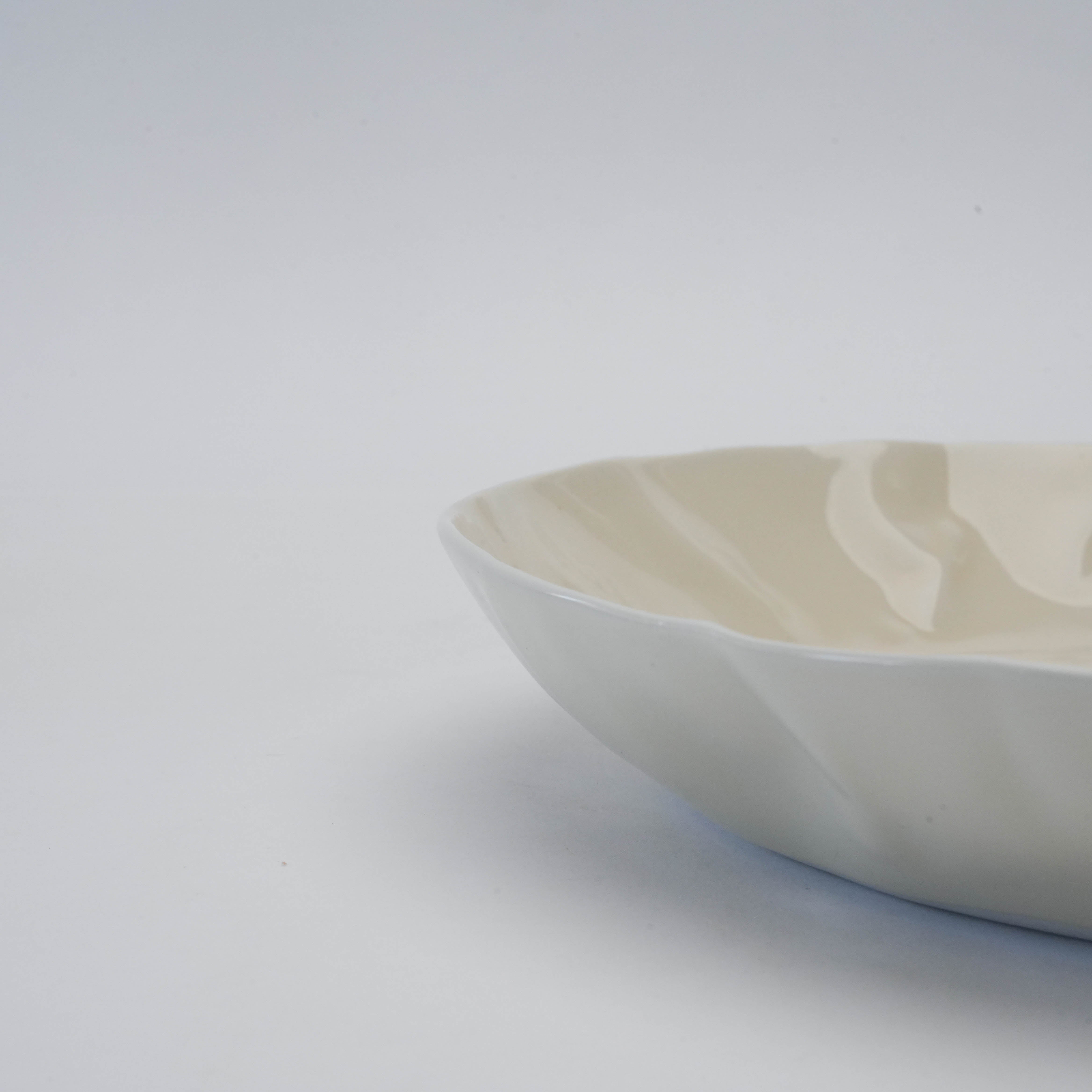 Angled side view of white Hasami Ware Pasta Dish highlighting its shallow depth and papyrus-inspired rim for contemporary dining.
