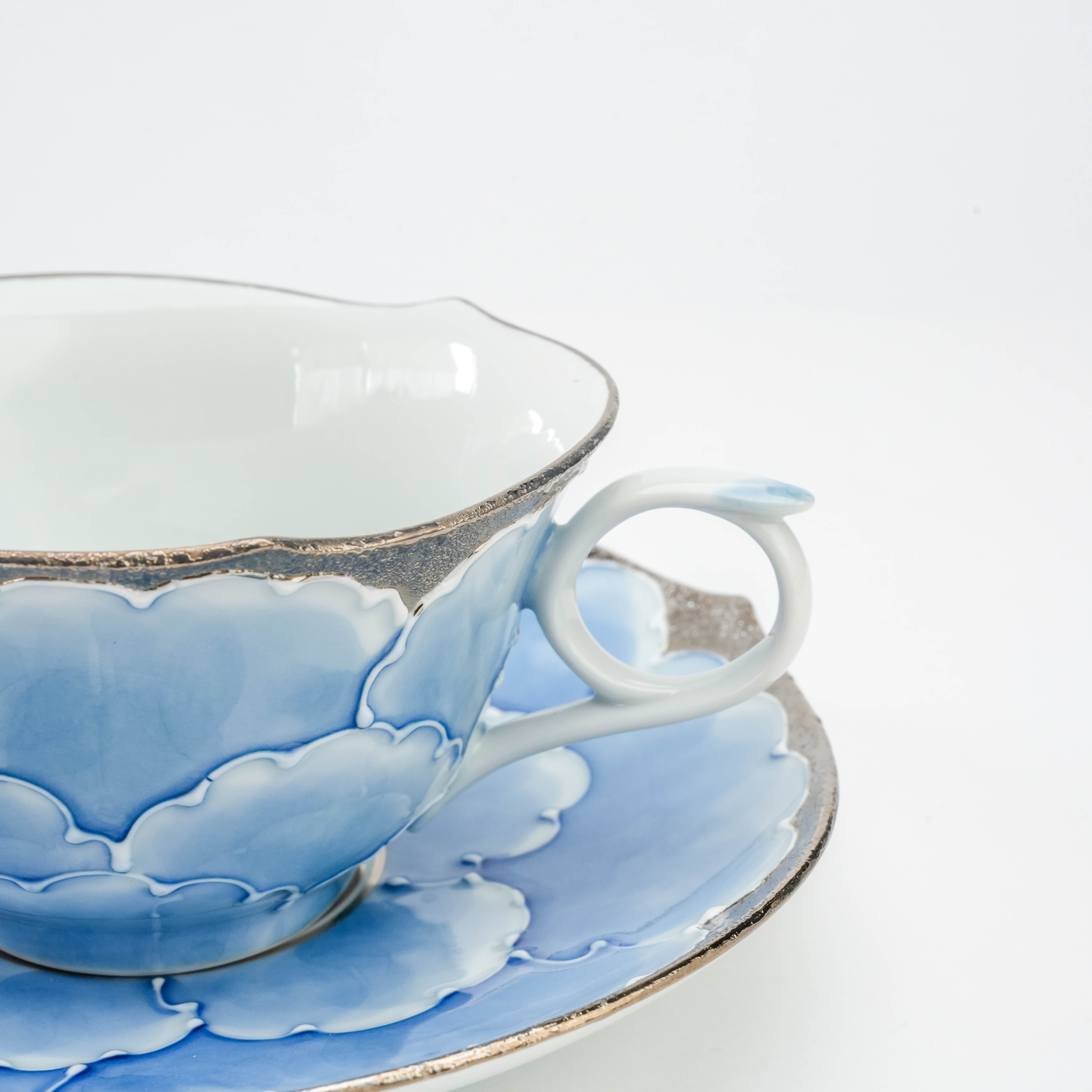 Detail of Bunzan Kiln Cup handle and rim highlighting the delicate blue peony motif and silver trim, showcasing Japanese porcelain artistry.