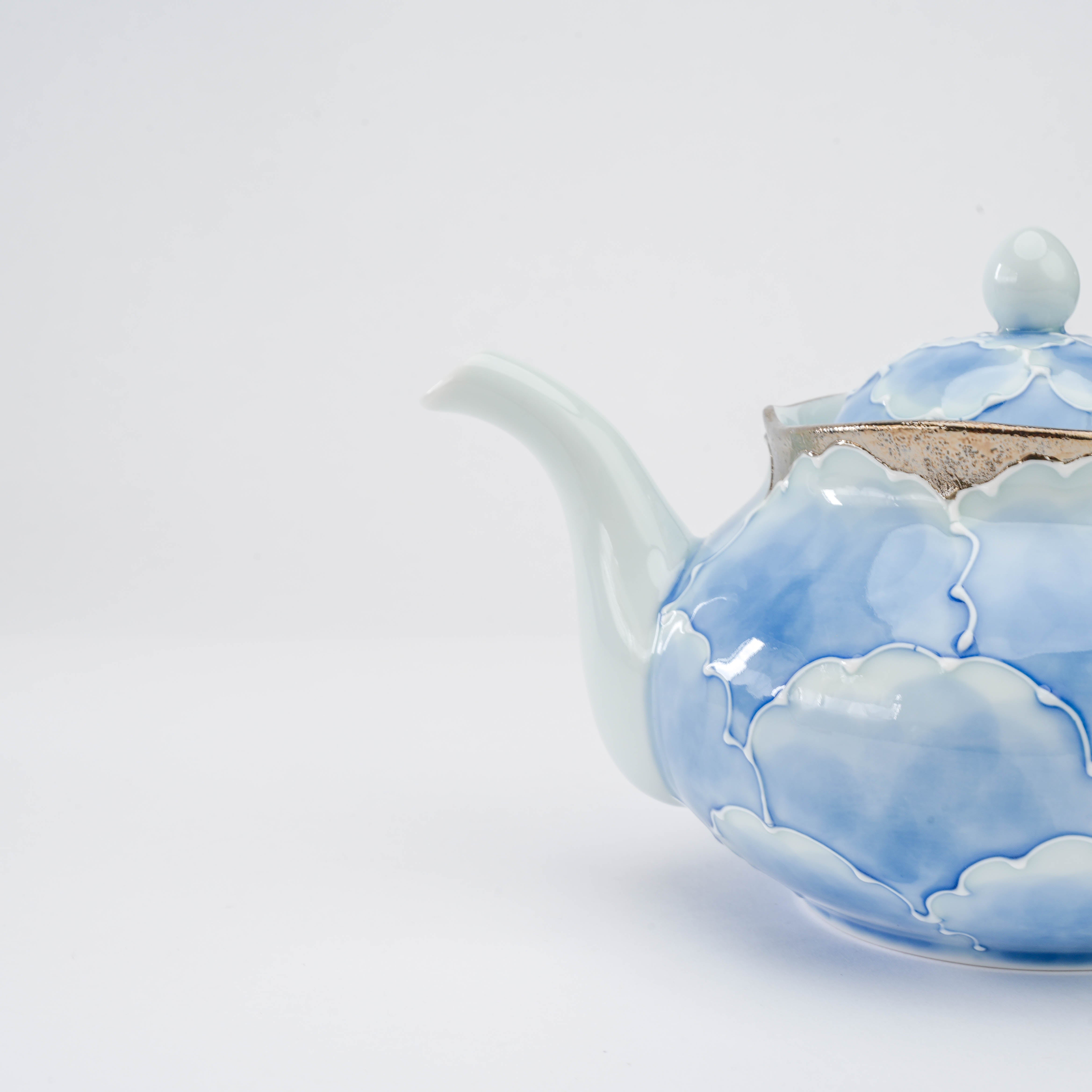 Close-up of the Bunzan Arita Peony Teapot spout and silver-trimmed rim, emphasizing the delicate blue peony petal motif.