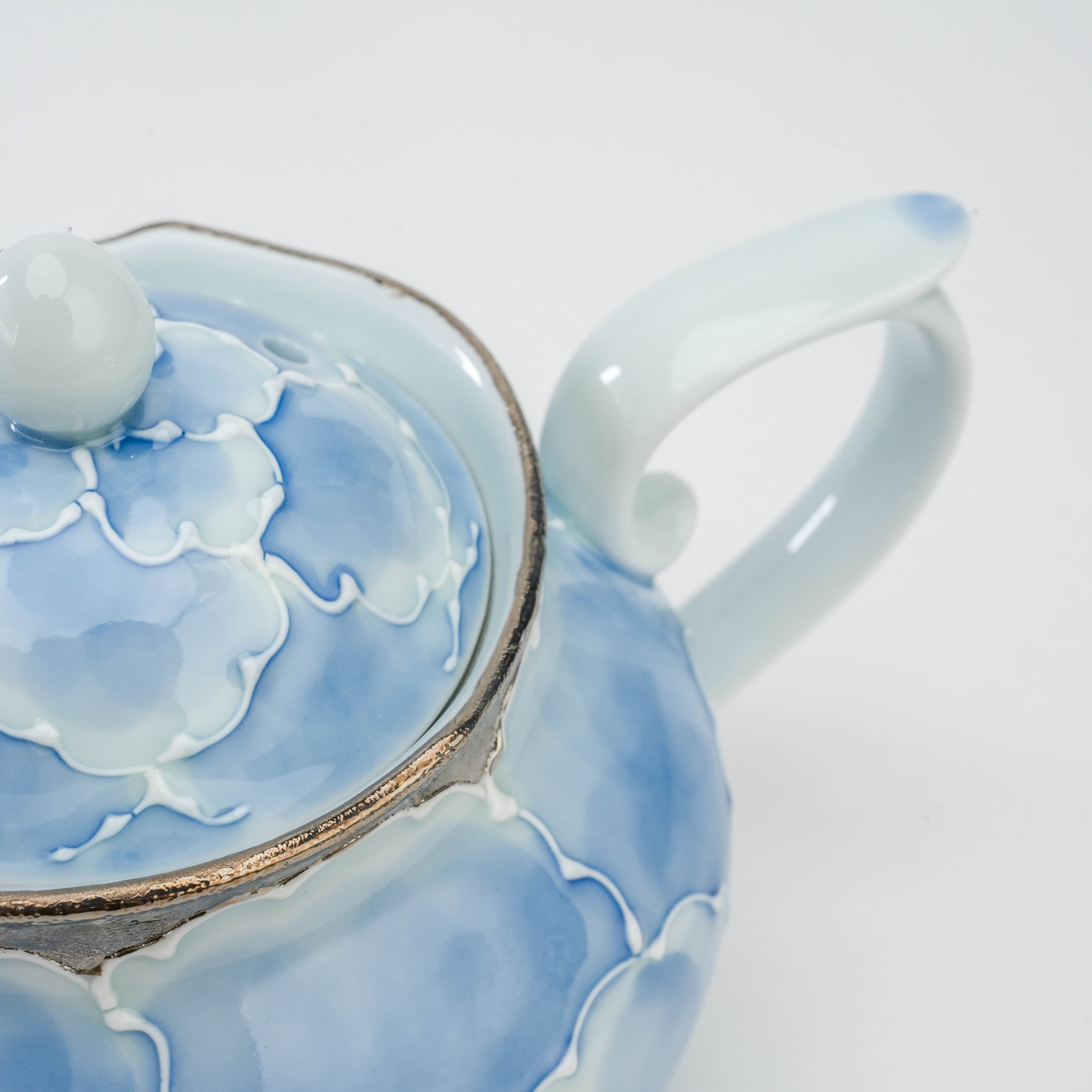 Handle and lid detail of the Bunzan Arita Peony Teapot, highlighting the hand-painted blue petals and platinum accent.