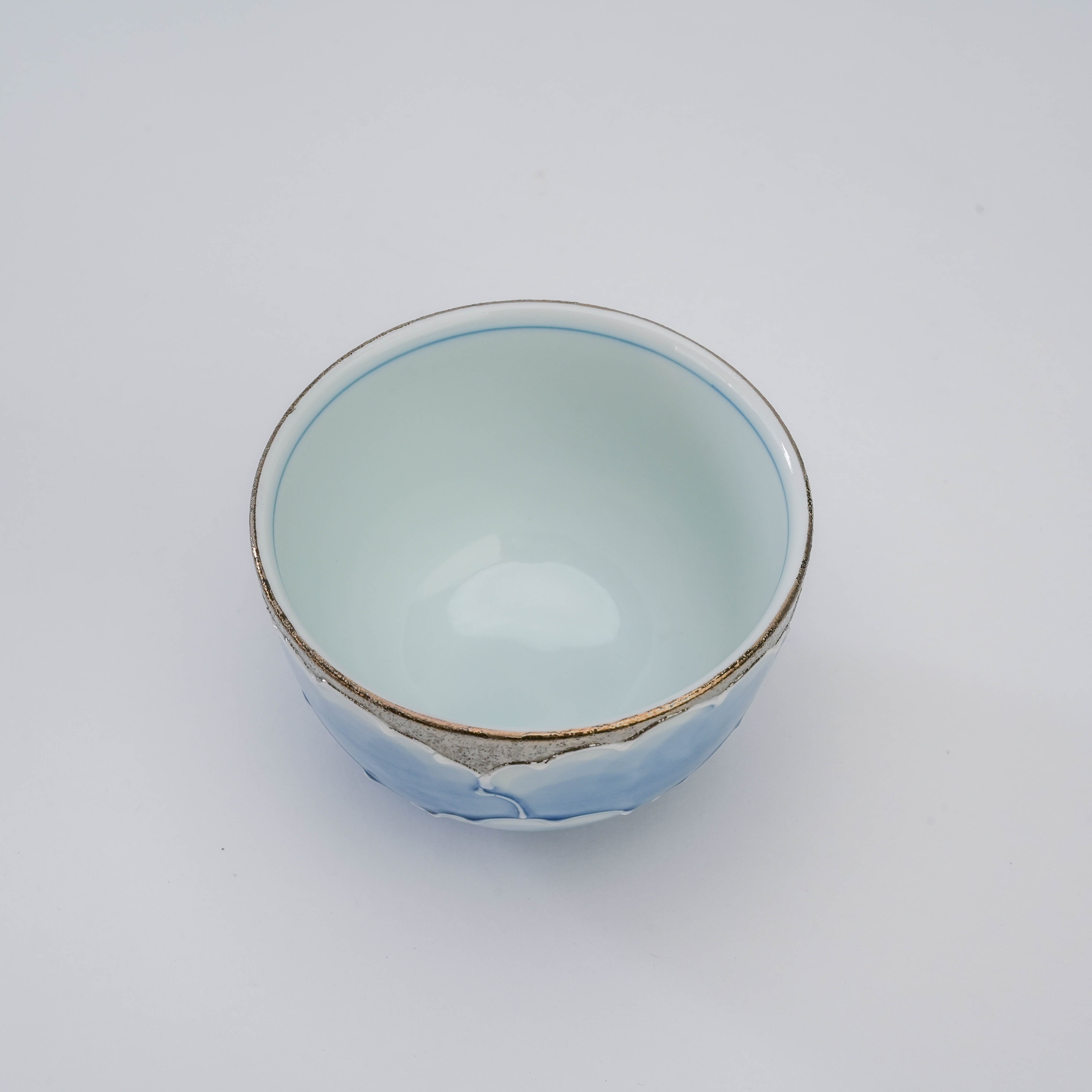 Top view of Bunzan Kiln Peony Tea Cup showing smooth porcelain interior and silver-trimmed rim, part of the Platinum Series Arita Ware.