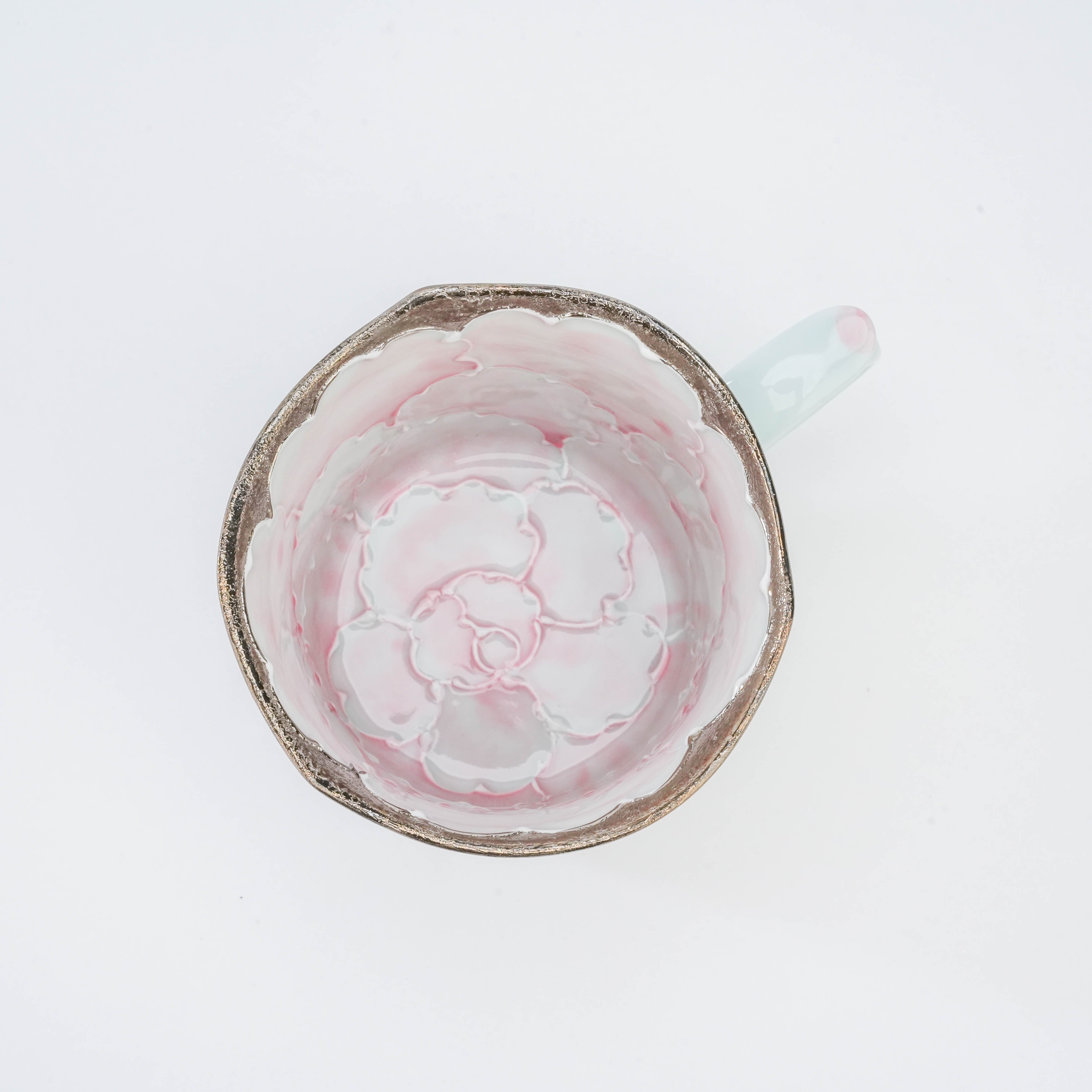 Overhead view of Peony Mug by Bunzan Kiln showcasing full pink peony bloom design and silver trim inside the porcelain cup.