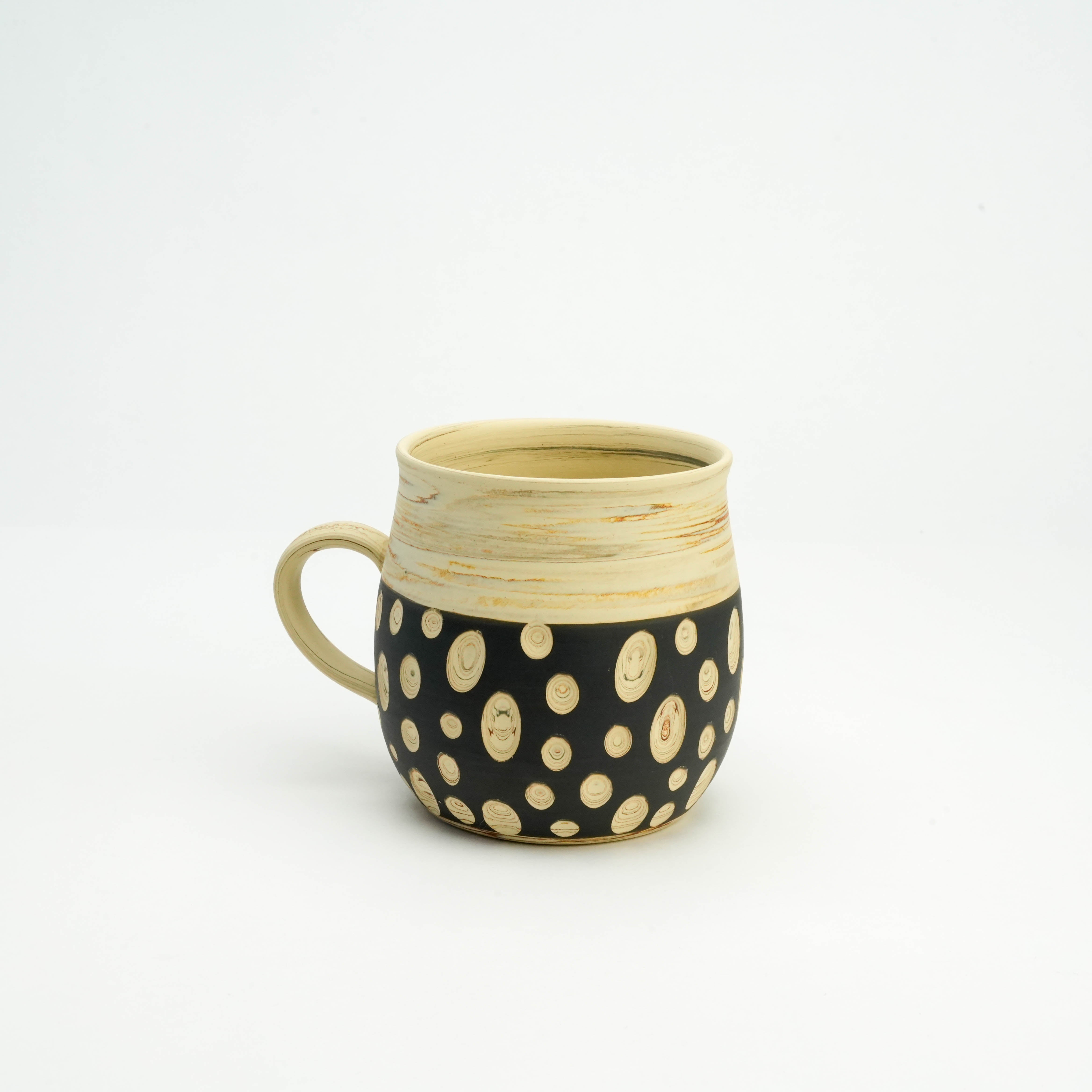 Handcrafted Tokoname Ware Mug in black with concentric polka dots and smooth cream top, designed by Kenji Touen for stylish drinkware use.