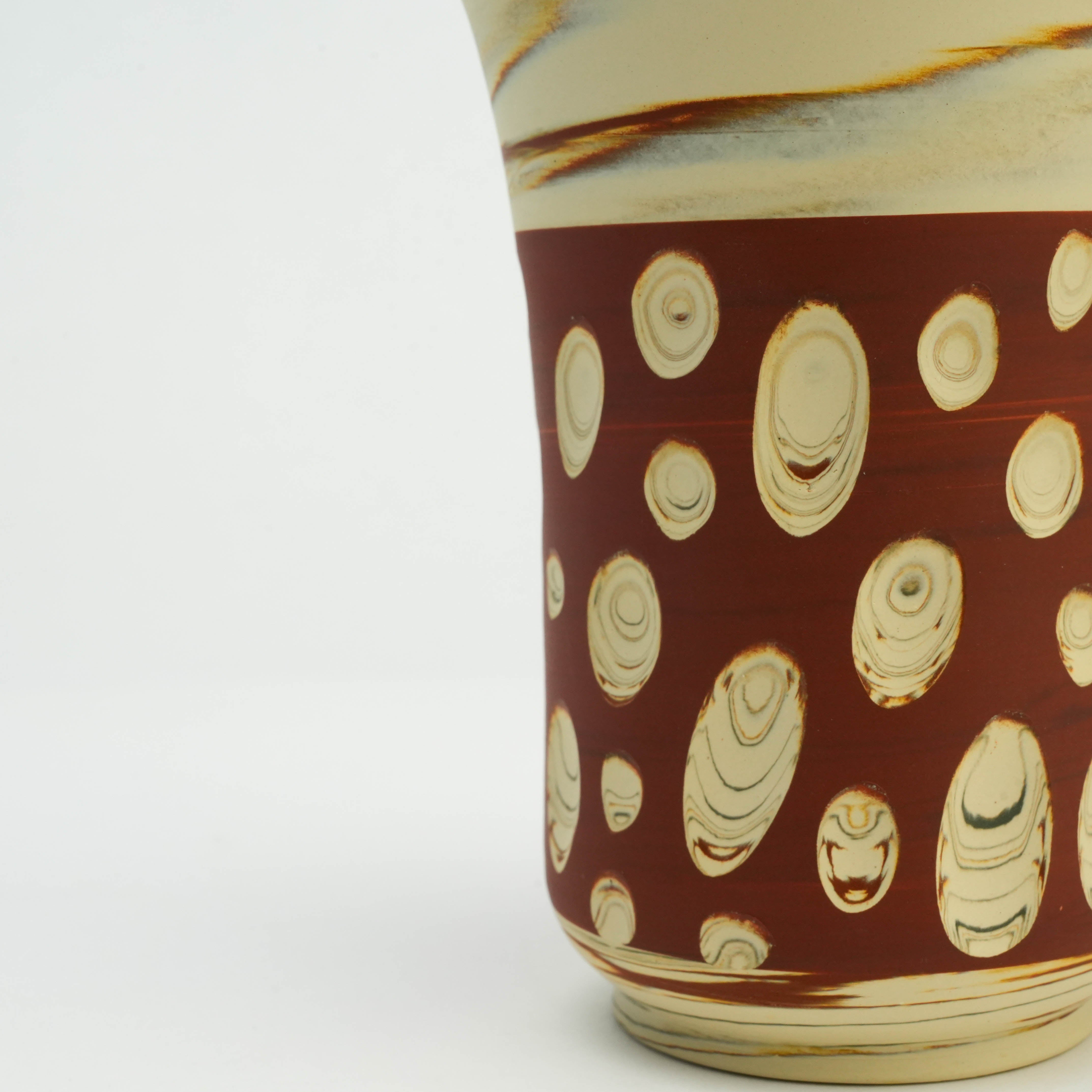 Detailed view of Tokoname Ware Red Tumbler's textured polka dot pattern on red clay, showcasing artisanal ceramic design.