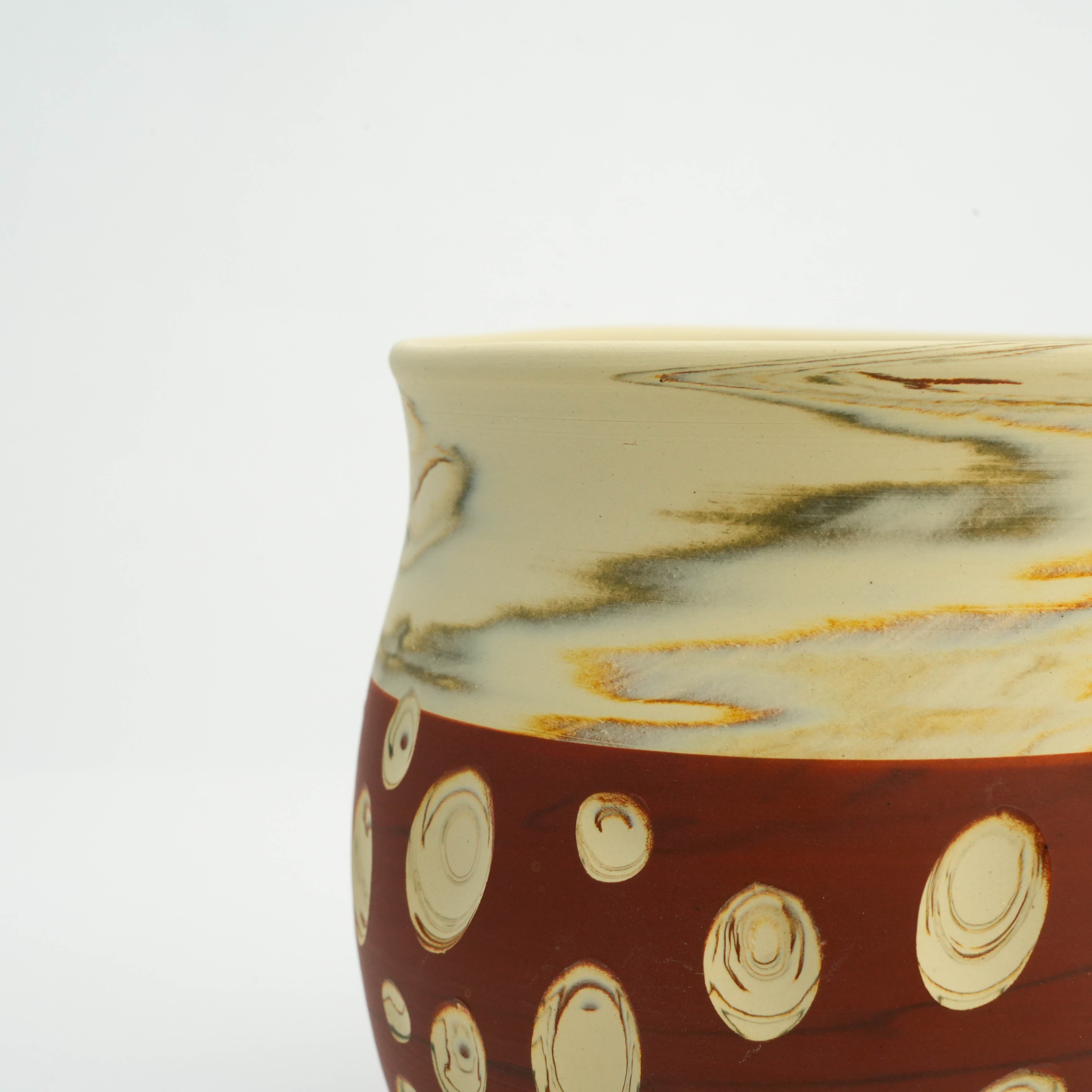 Close-up of Tokoname Ware Mug Red - Polka Dot Design showing marbled cream glaze and detailed dot carvings on red ceramic.