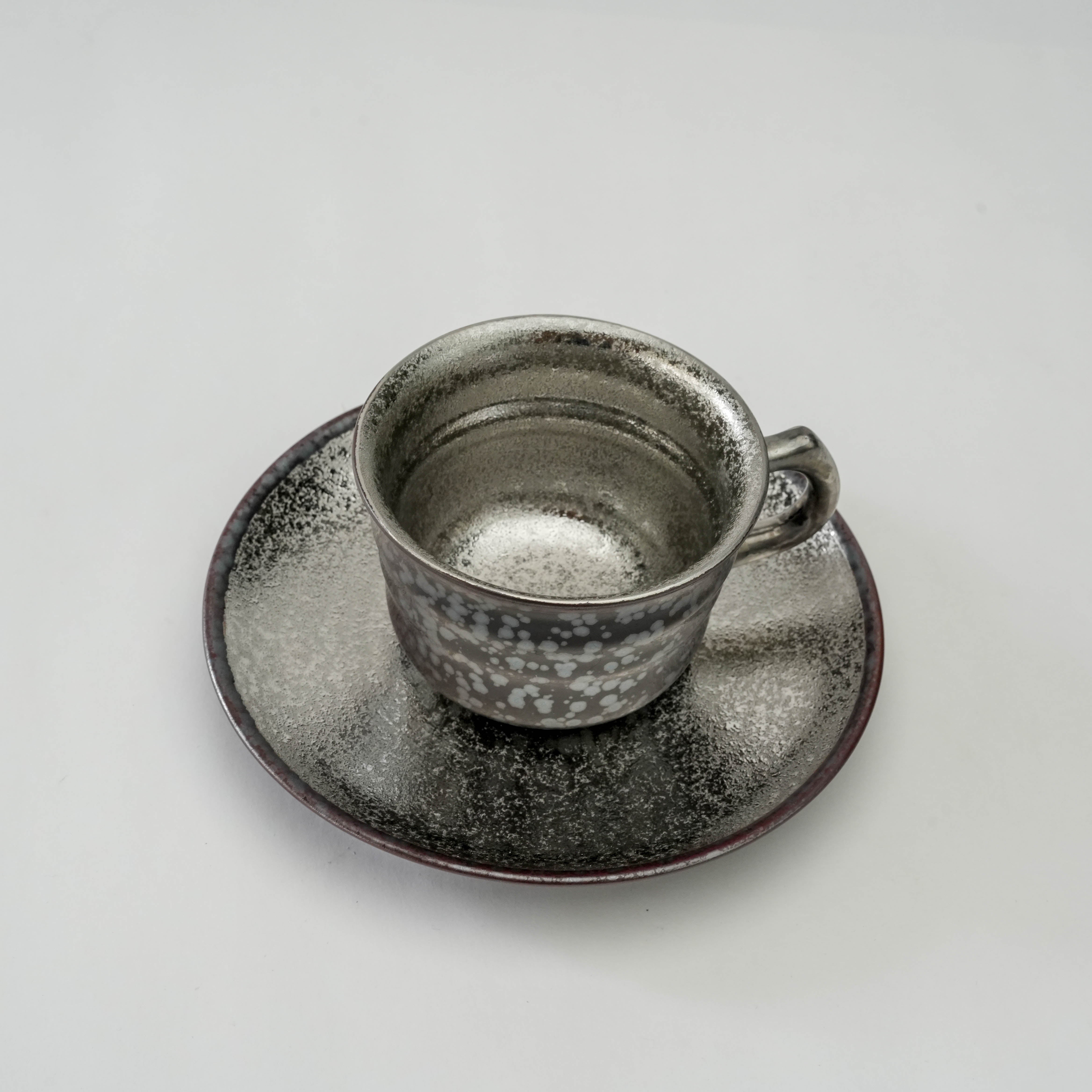Top view of Arita Ware Crystal Glaze Silver Coffee Cup & Saucer showcasing intricate metallic glaze and handcrafted texture. Perfect for refined tableware.