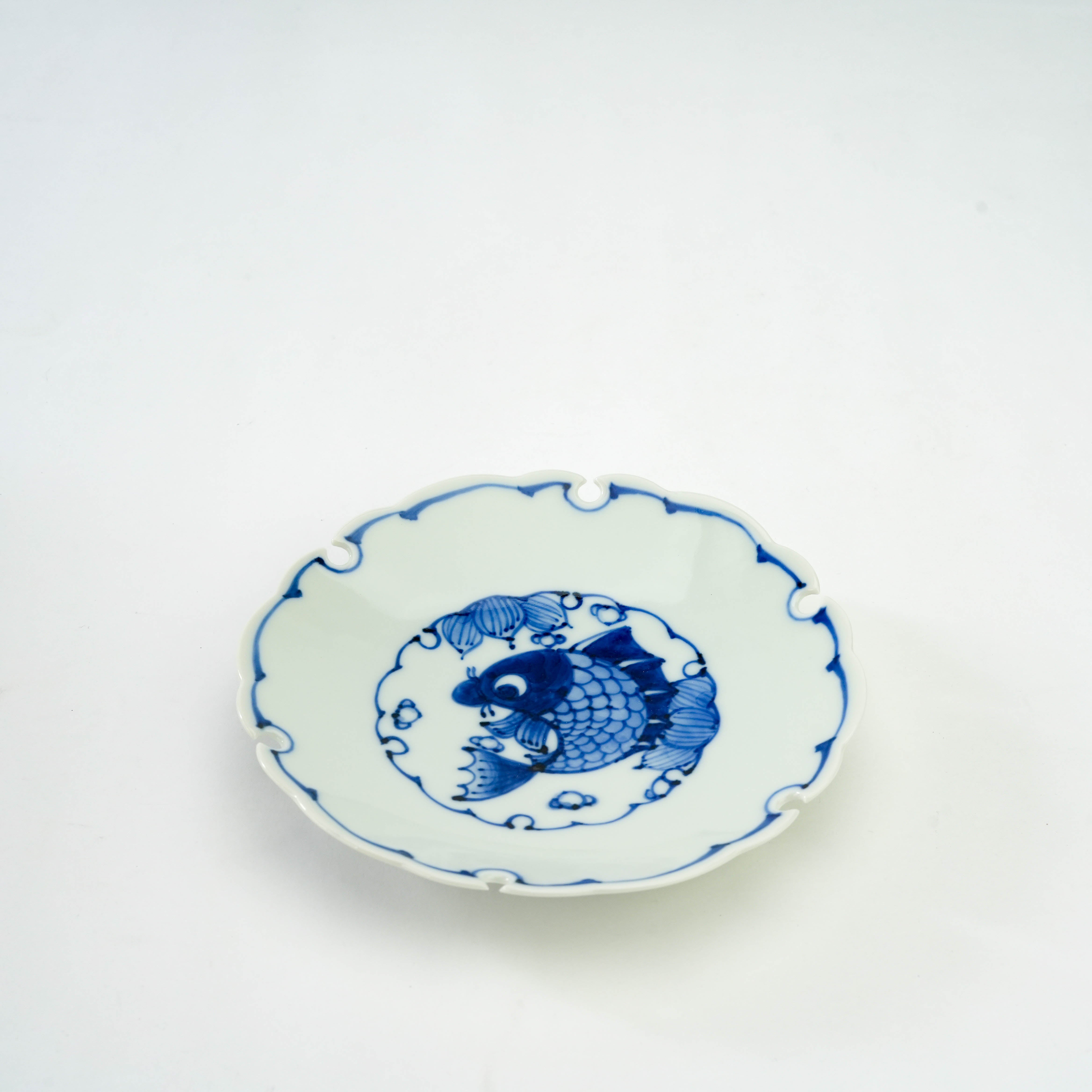 Hand-painted Arita Ware Snow Circle Plate featuring a blue fish motif and scalloped rim, perfect for elegant table settings or gifting.