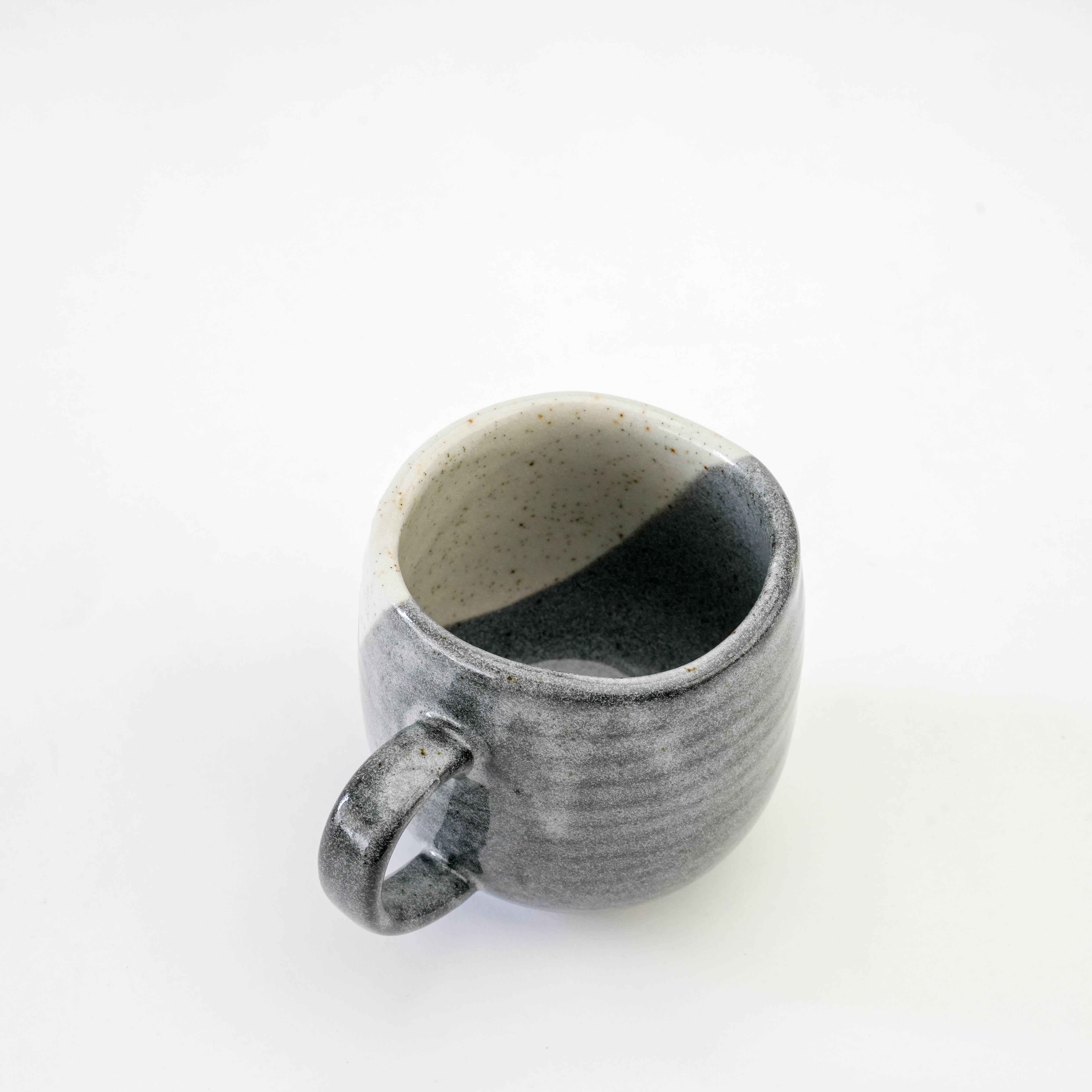 Top view of the Kutani Cat Yunomi Teacup revealing its speckled interior and asymmetrical rim, highlighting artisanal craftsmanship.