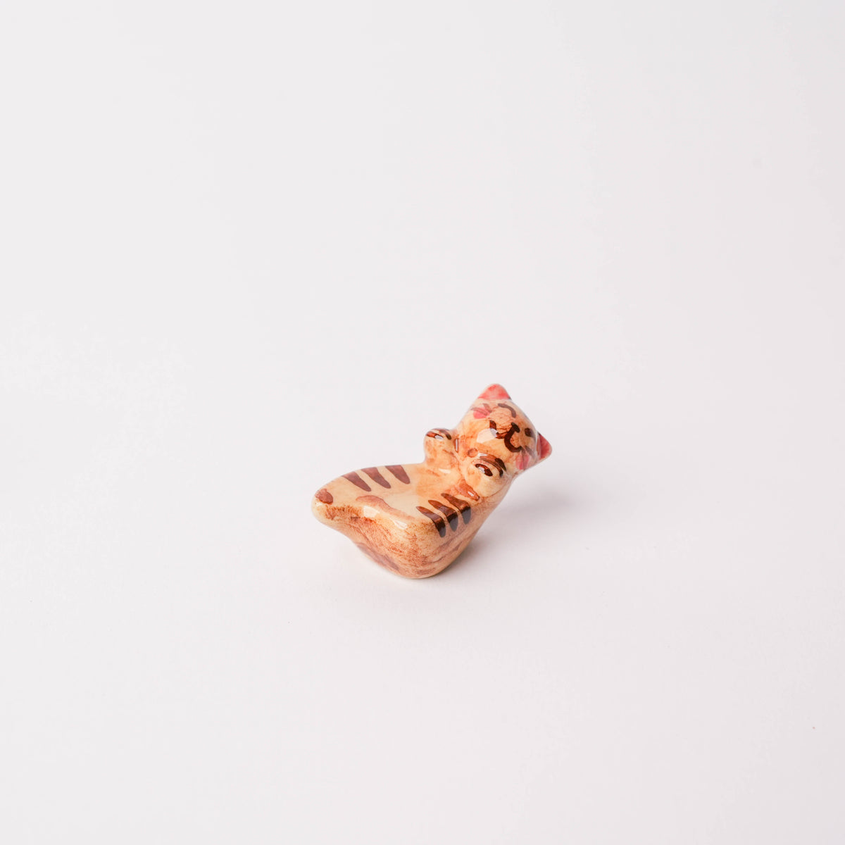 Top angle of the porcelain cat chopstick rest with playful painted design, small size for tableware decoration