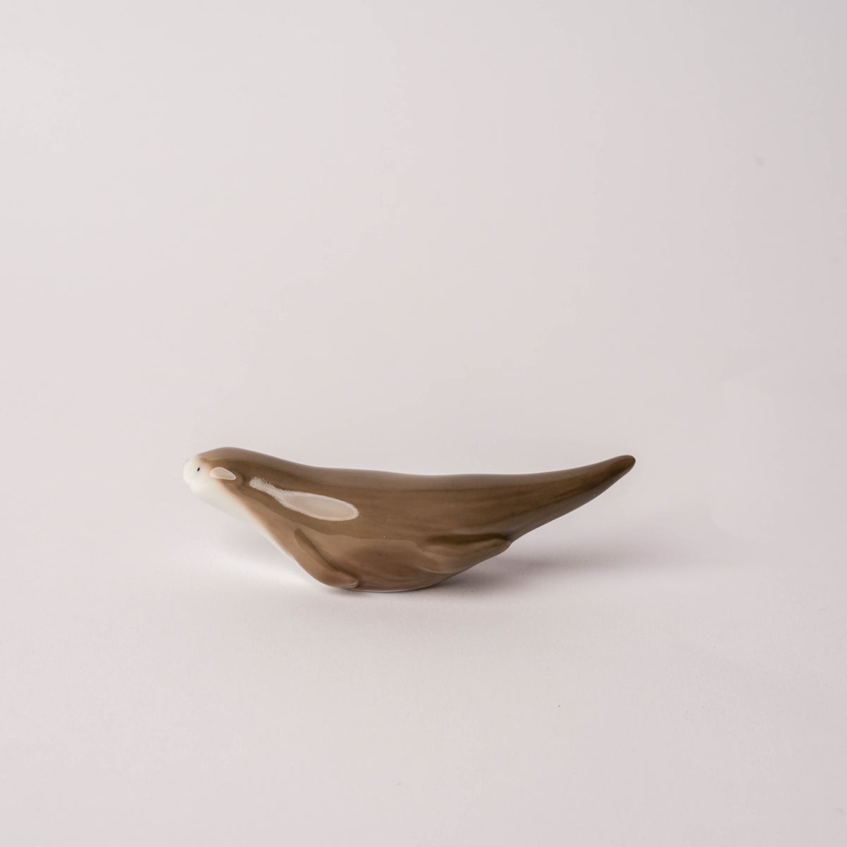 Side view of the ceramic otter chopstick rest highlighting its elongated body and realistic design, ideal for tableware accessories.