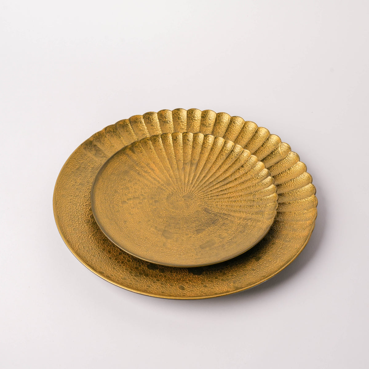 Close-up of a gold-colored ceramic plate with textured, scalloped edge and intricate bubble pattern, part of Japanese dinnerware