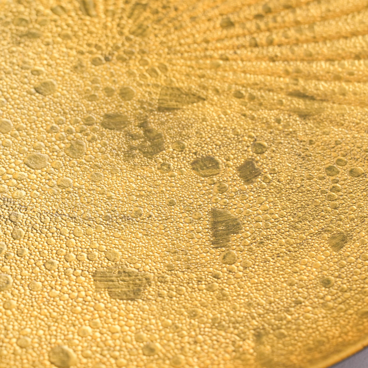 Close-up of the black and gold ceramic plate's textured edge with a hint of the decorative pattern, Japanese dinnerware