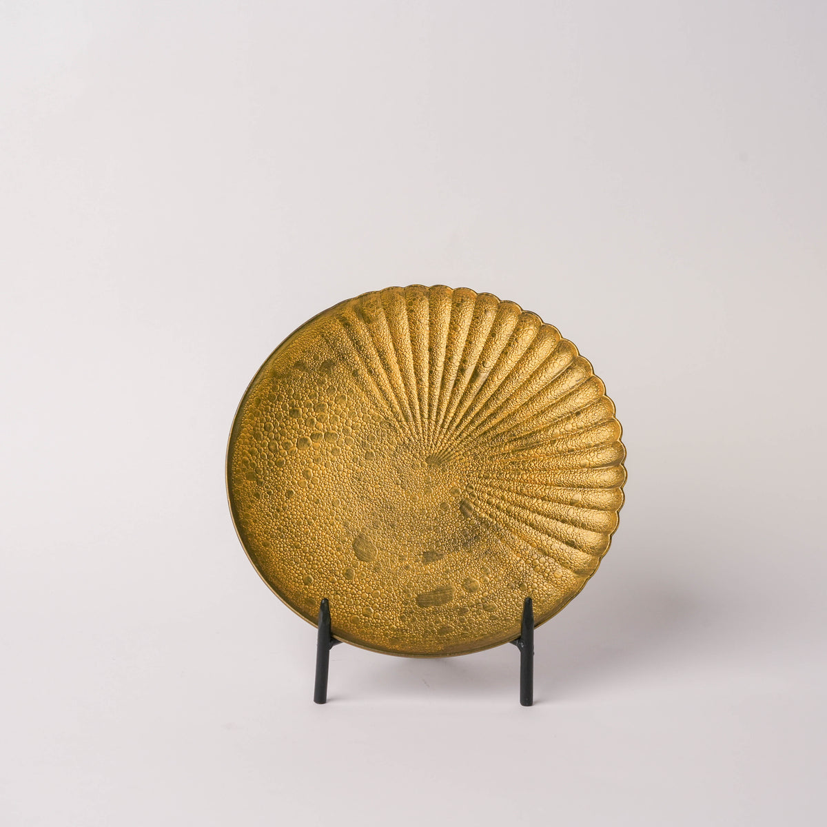 Gold-colored ceramic plate with textured bubble glaze and scalloped edge, featuring a chrysanthemum carving design, displayed on a black stand against a white background.