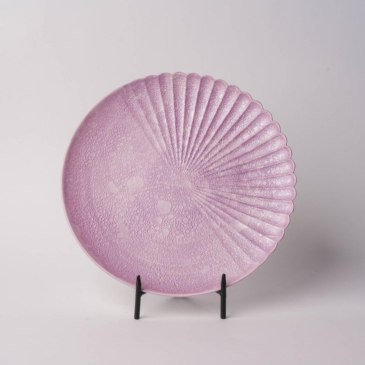 Pink bubble textured glass plate with scalloped edge, detailed macro shot highlighting intricate surface pattern