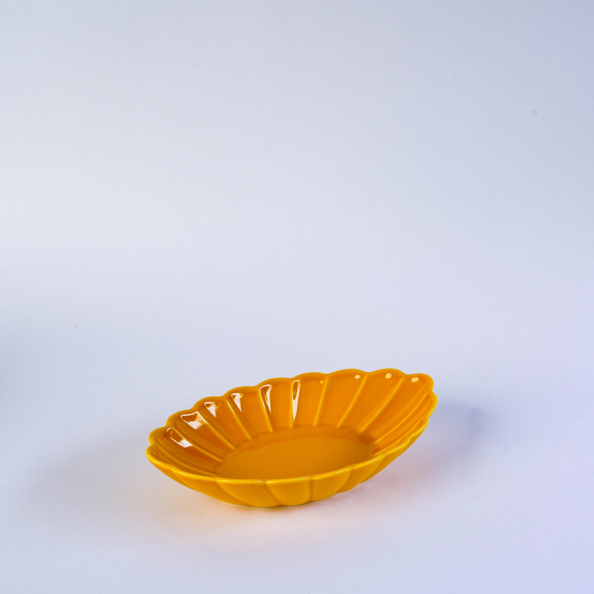 Bright yellow ceramic bowl with a scalloped edge and a glossy finish, perfect for serving snacks or desserts on a white background
