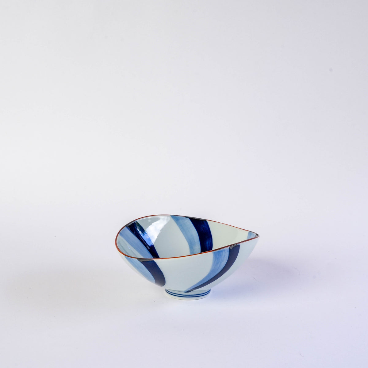 White ceramic bowl with flowing water motifs in blue and red accents, oval shape, perfect for serving side dishes or desserts