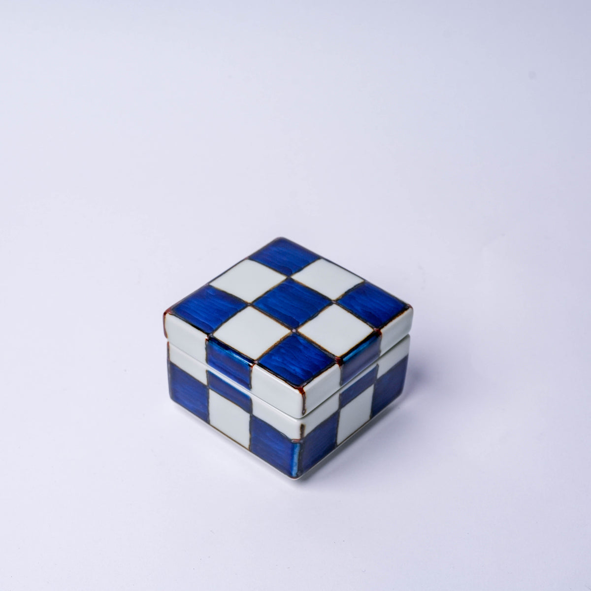 Top view of the porcelain checkerboard trinket box with blue and white squares, showing the removable lid and detailed craftsmanship