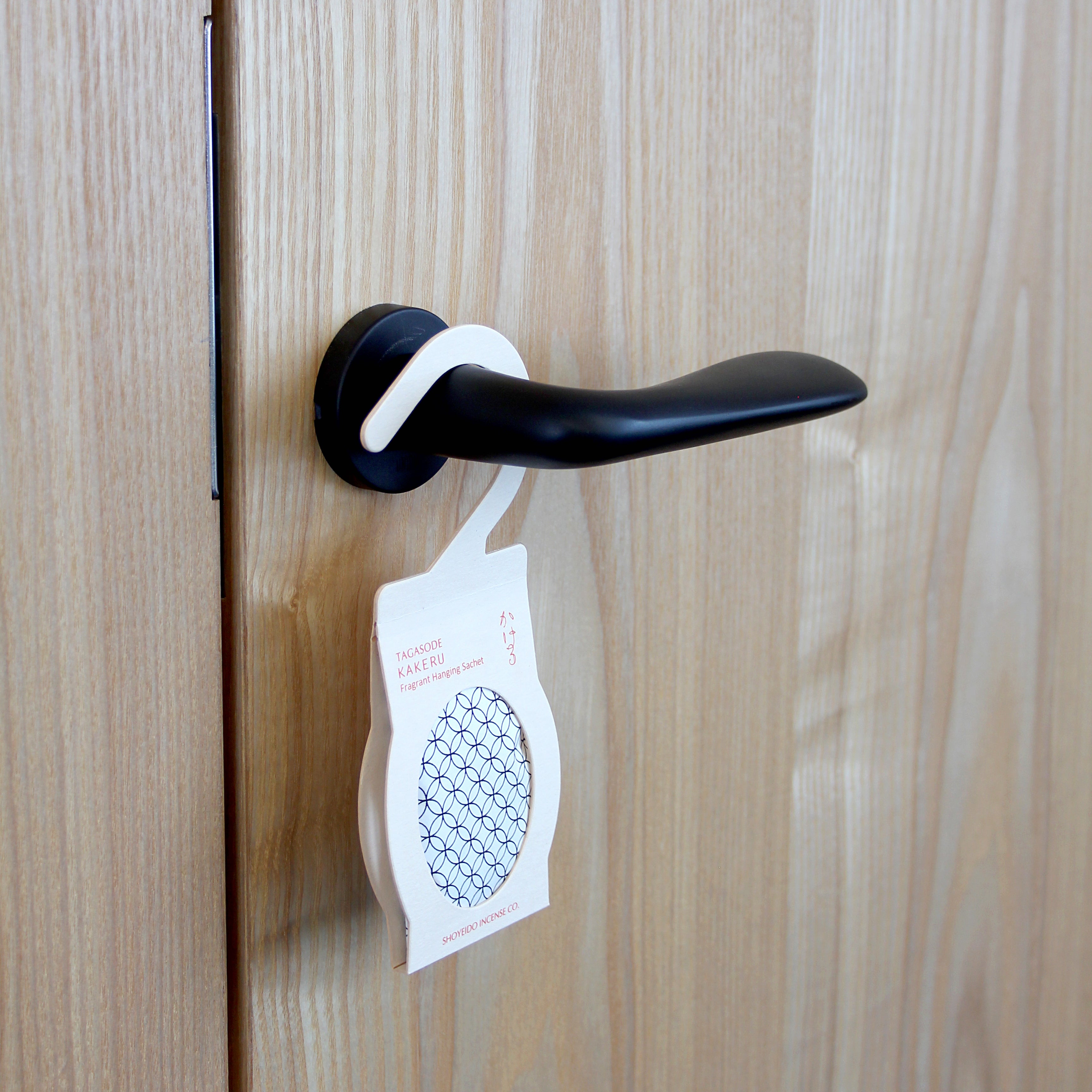 Beige Shoyeido Sachet on a door handle, stylishly freshening rooms with sandalwood and herbal fragrance.