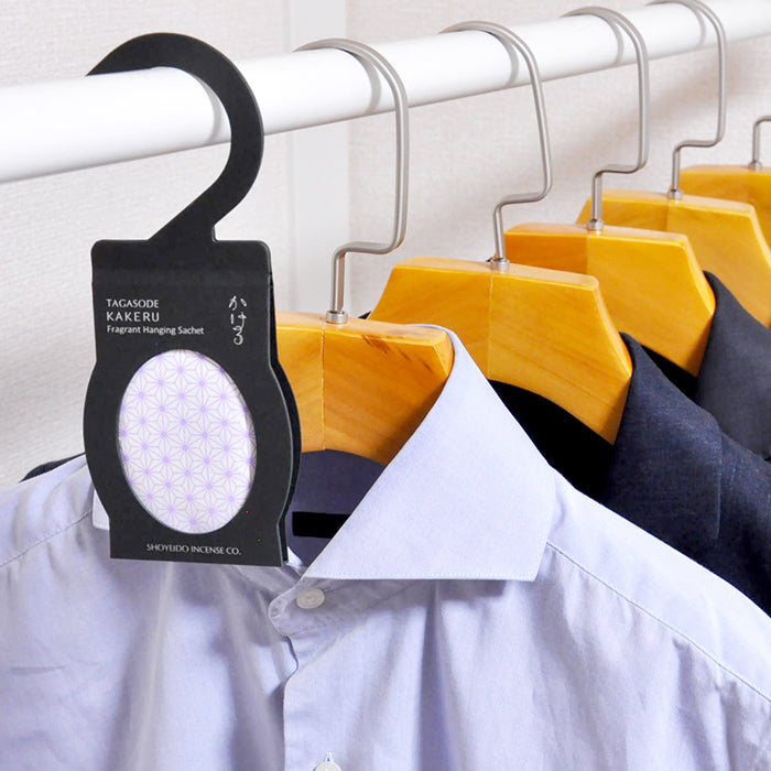 Shoyeido Fragrant Sachet hanging in a closet with shirts, enhancing wardrobe with sandalwood and lavender scent.